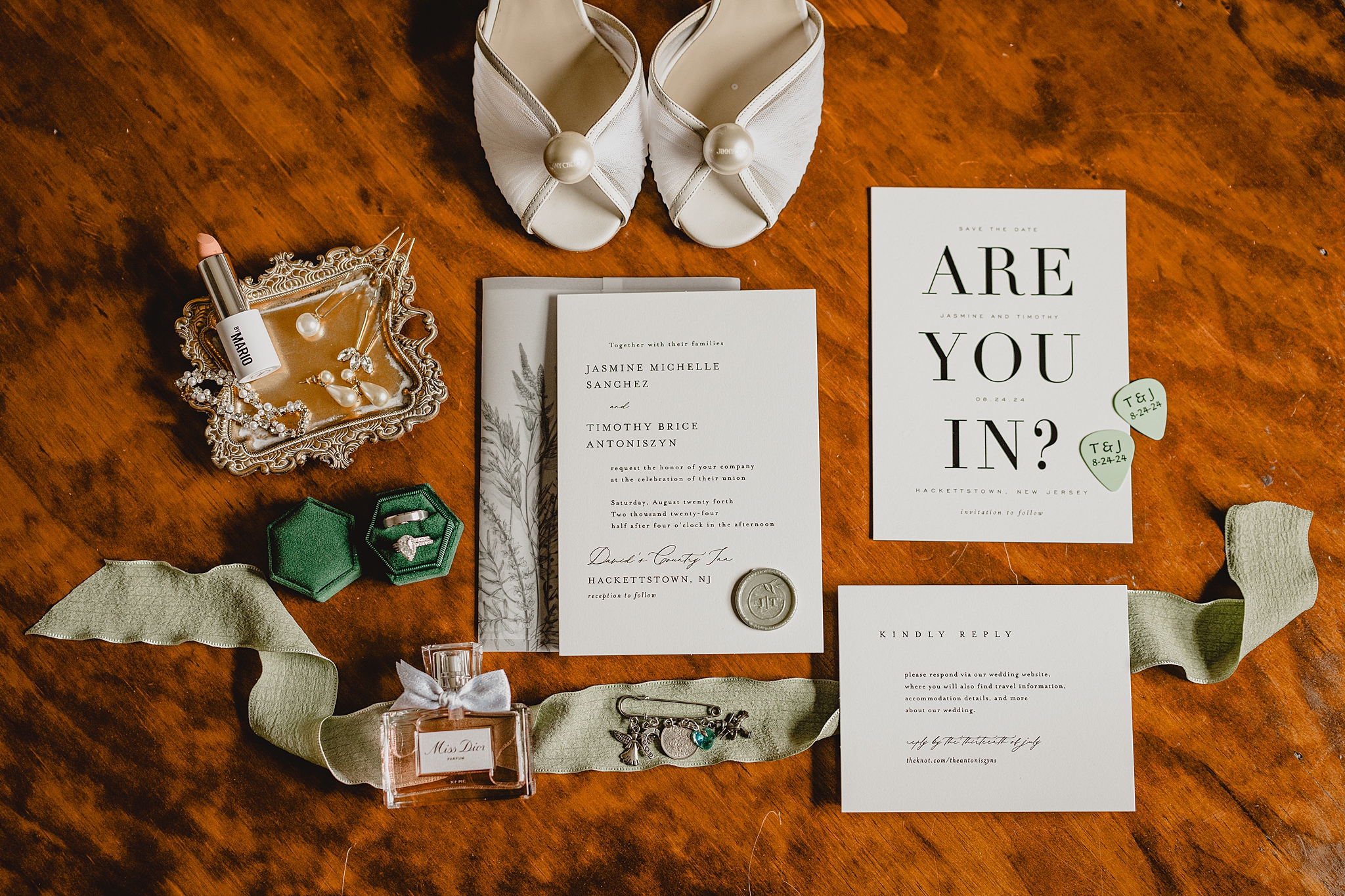 bride's ivory shoes with white and black invitation suite with green accents 
