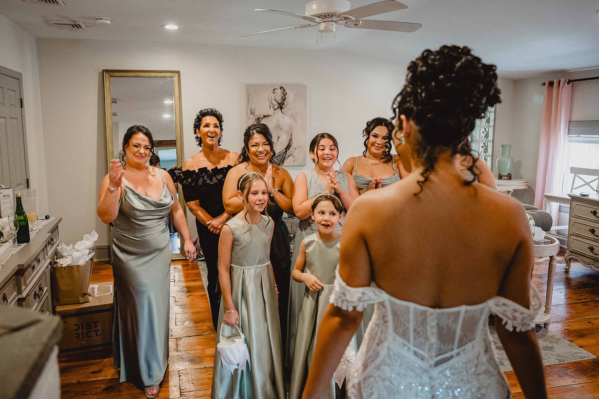 bridesmaids and flower girls in sage green dresses have first look with bride in suite at David's Country Inn