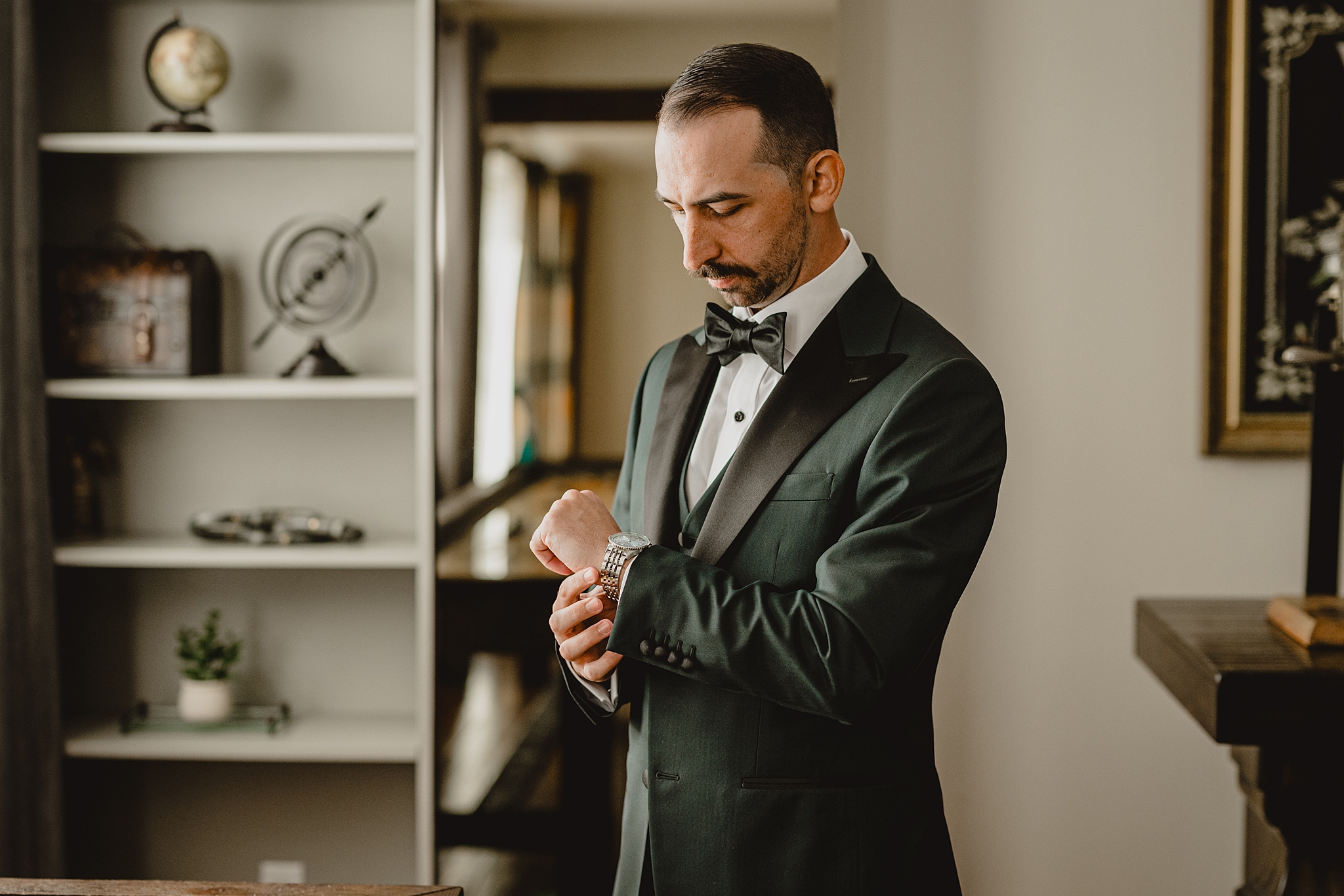 groom adjusts watch during prep for wedding day at David's Country Inn