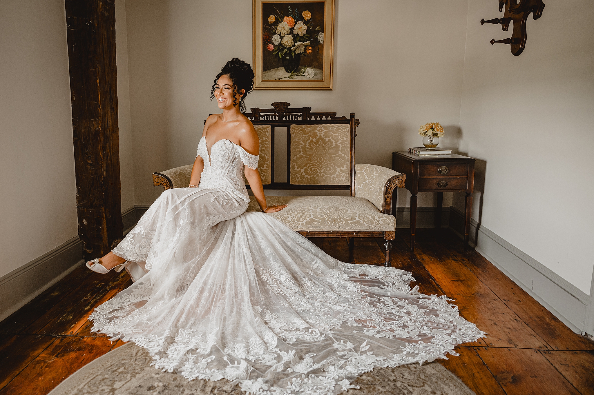 bride sits on tan couch in bridal suite in strapless gown in Hackettstown NJ