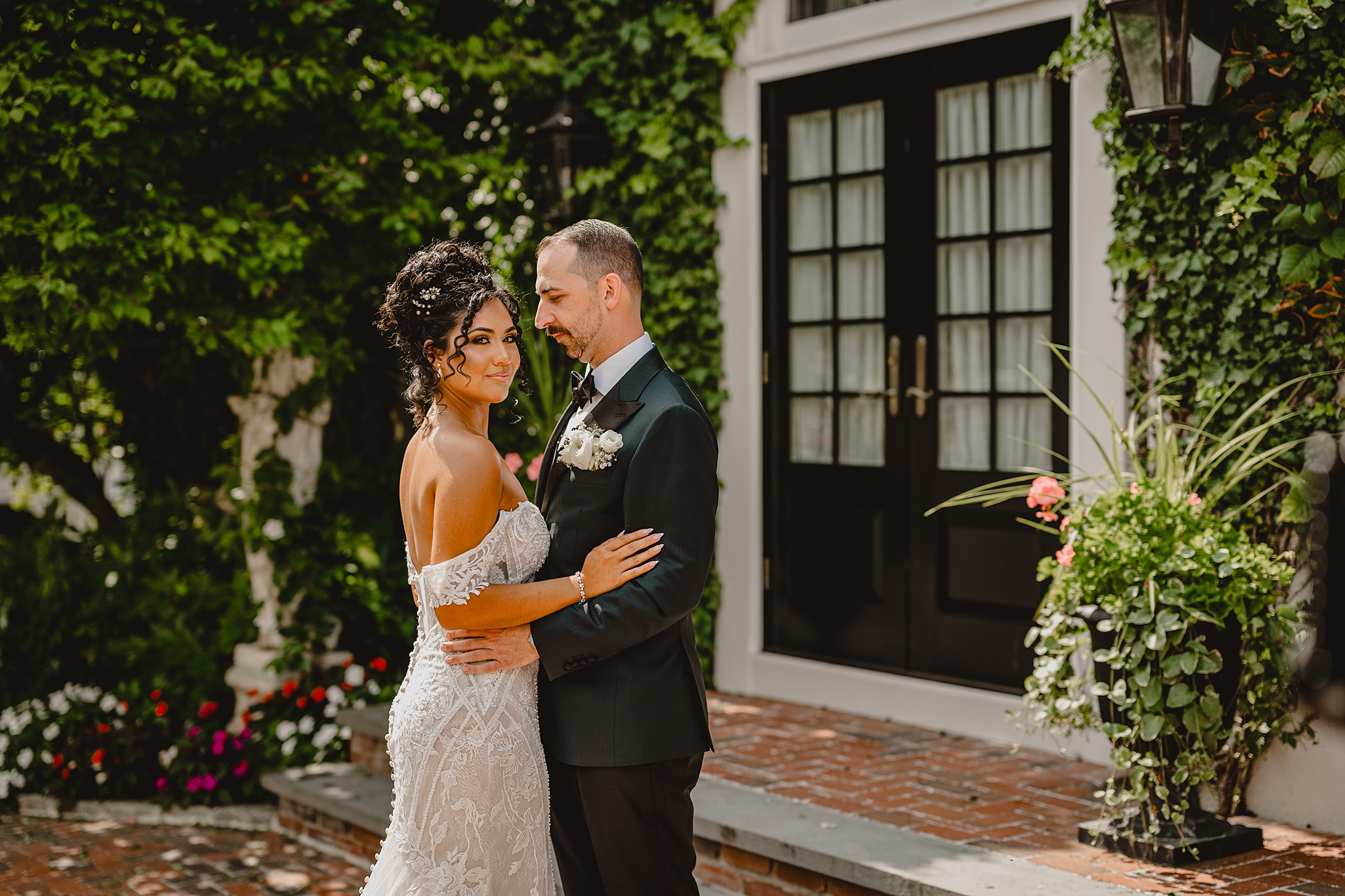 bride and groom hug on brick patio at David's Country Inn