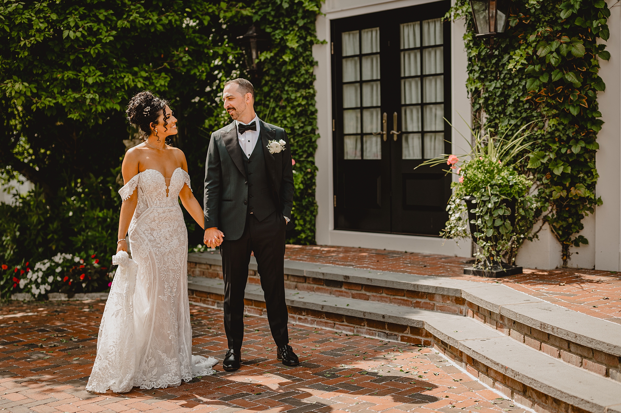 bride and groom hold hands walking on brick patio at David's Country Inn