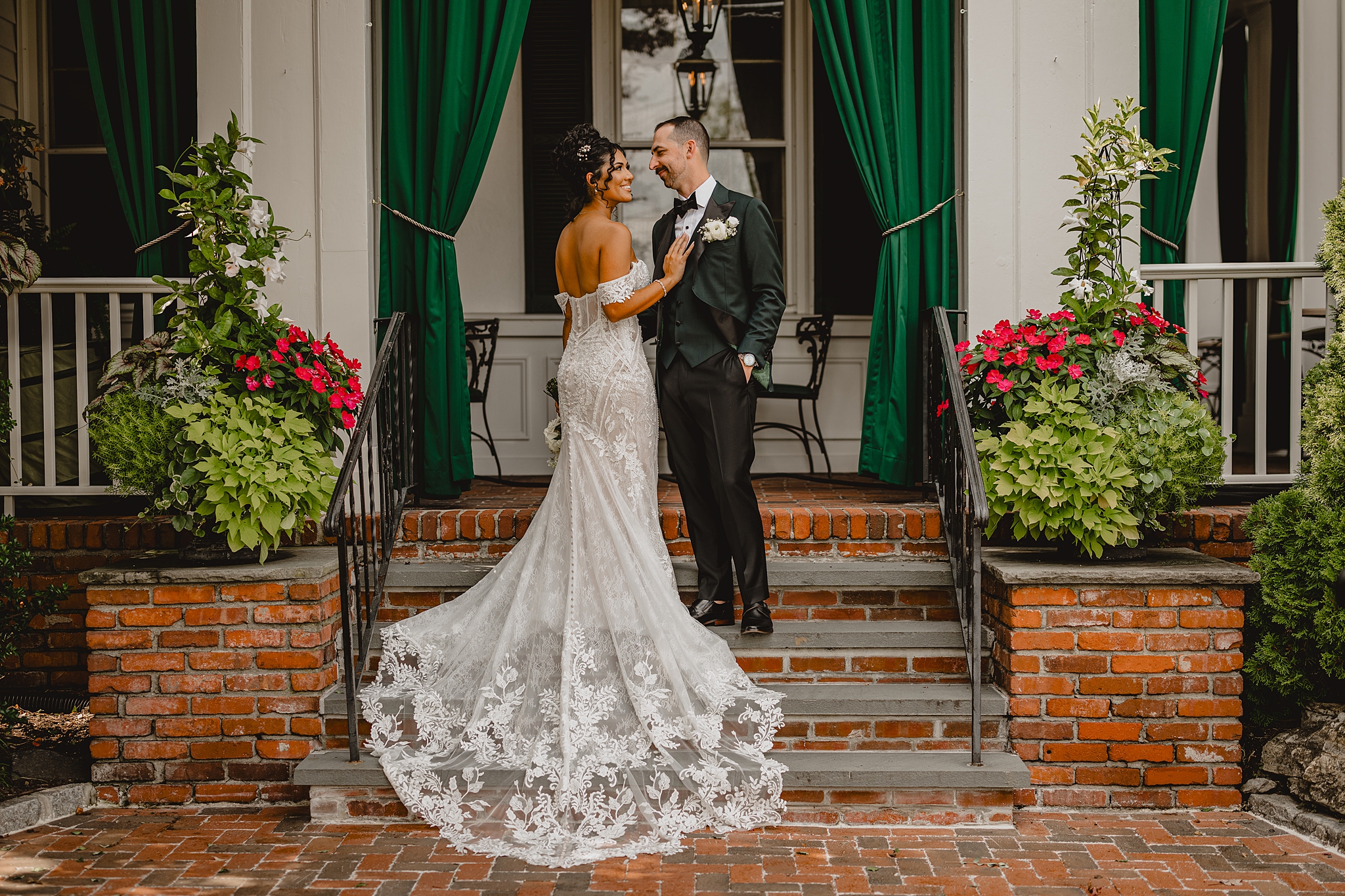 bride and groom stand on staircase outside David's Country Inn smiling at each other