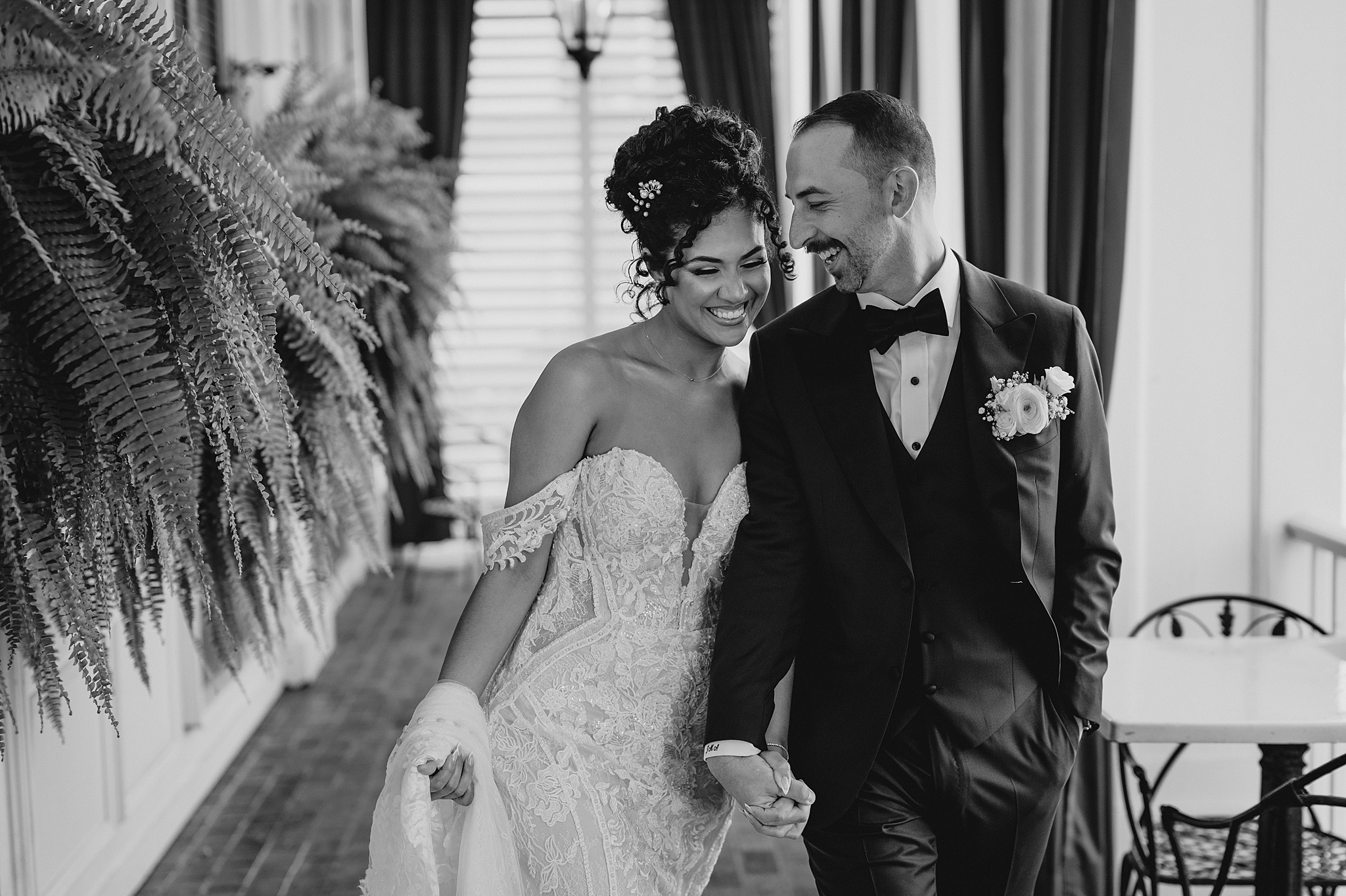 bride and from laugh holding hands walking on outside patio at David's Country Inn