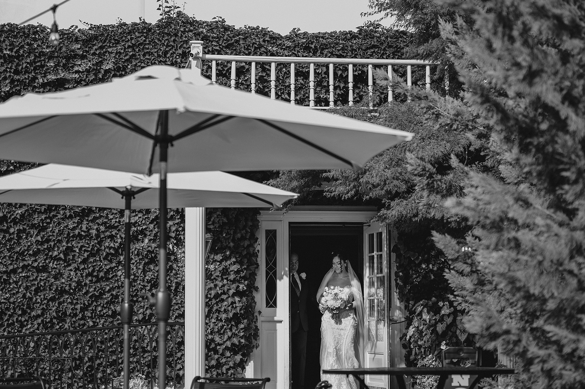 bride and father walk out of doorway at David's Country Inn for wedding ceremony 