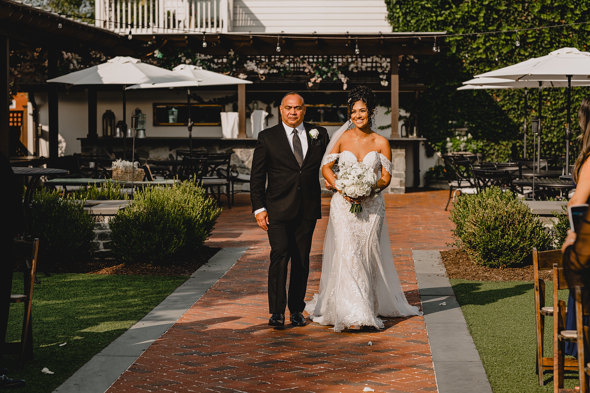 father escorts bride down aisle on patio at David's Country Inn