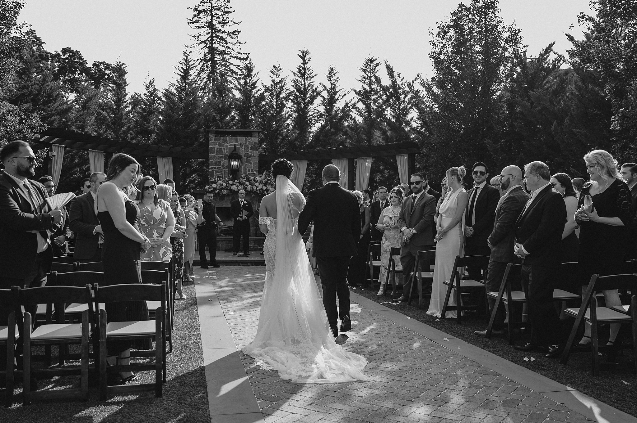 bride and dad walk up the aisle outside on the patio at David's Country Inn