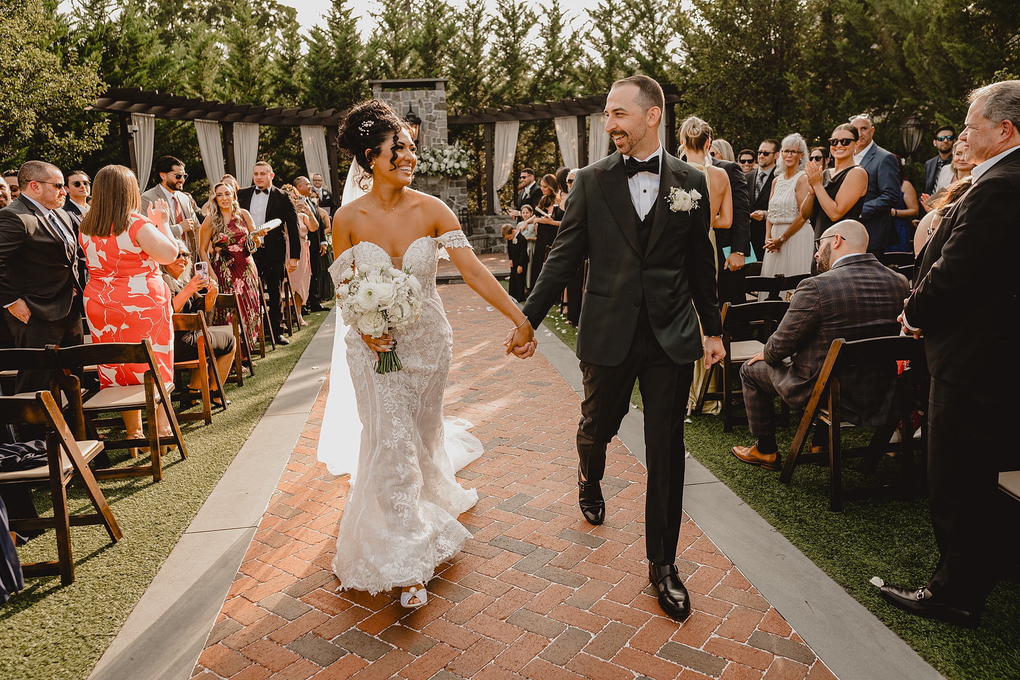 bride and groom hold hands walking away from wedding ceremony in Hackettstown NJ