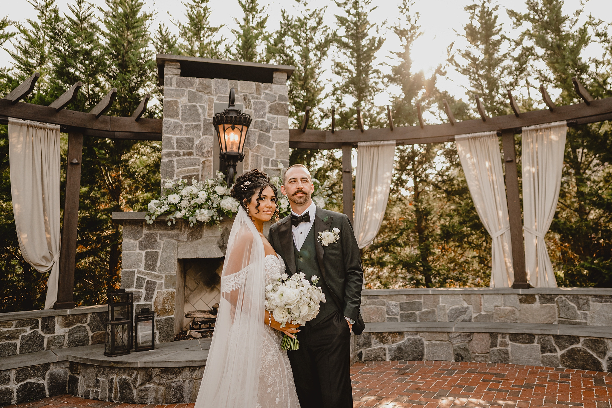 newlyweds hug standing in front of grey stone patio at David's Country Inn