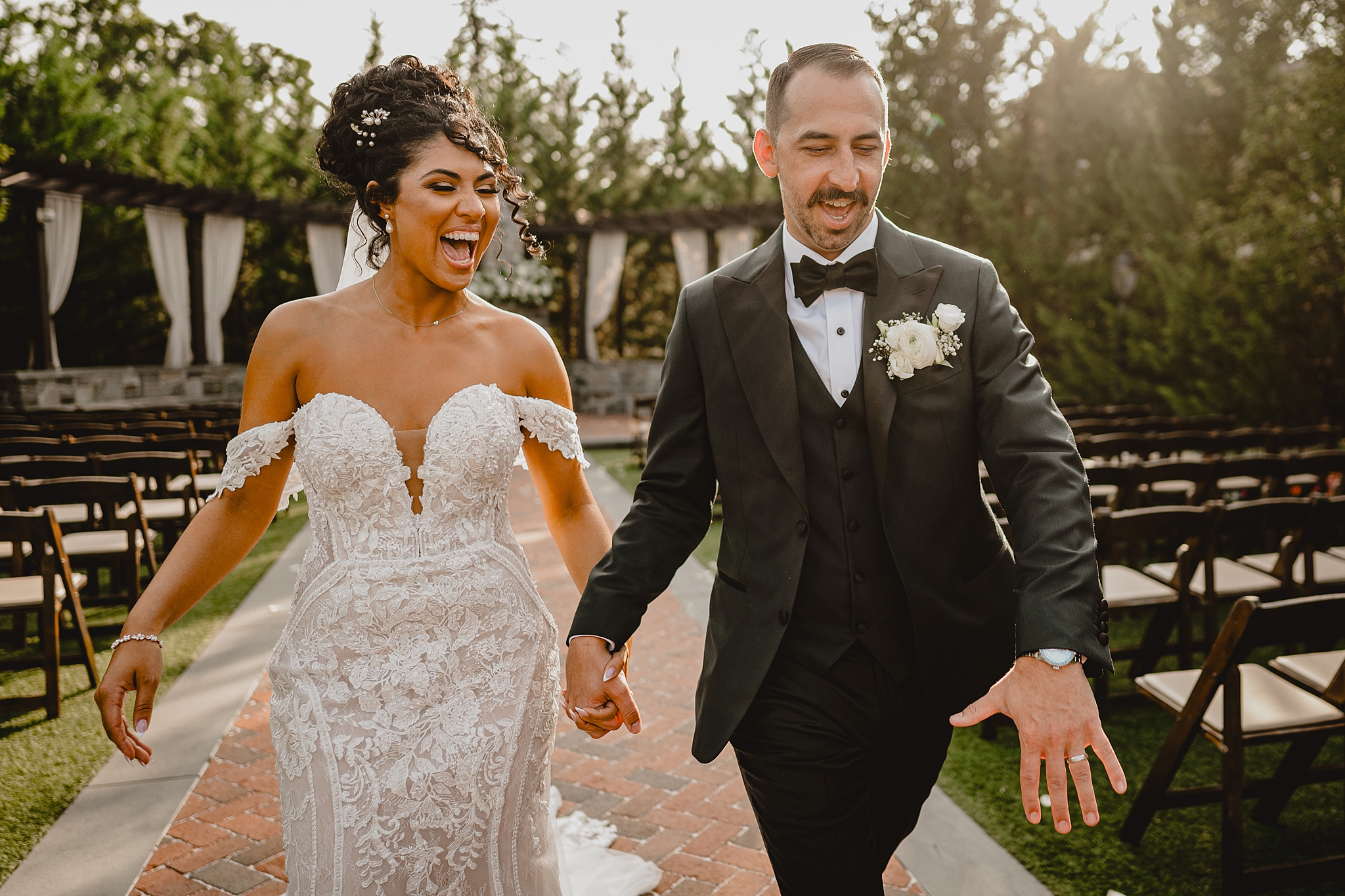 newlyweds laugh holding hands and running up aisle at David's Country Inn