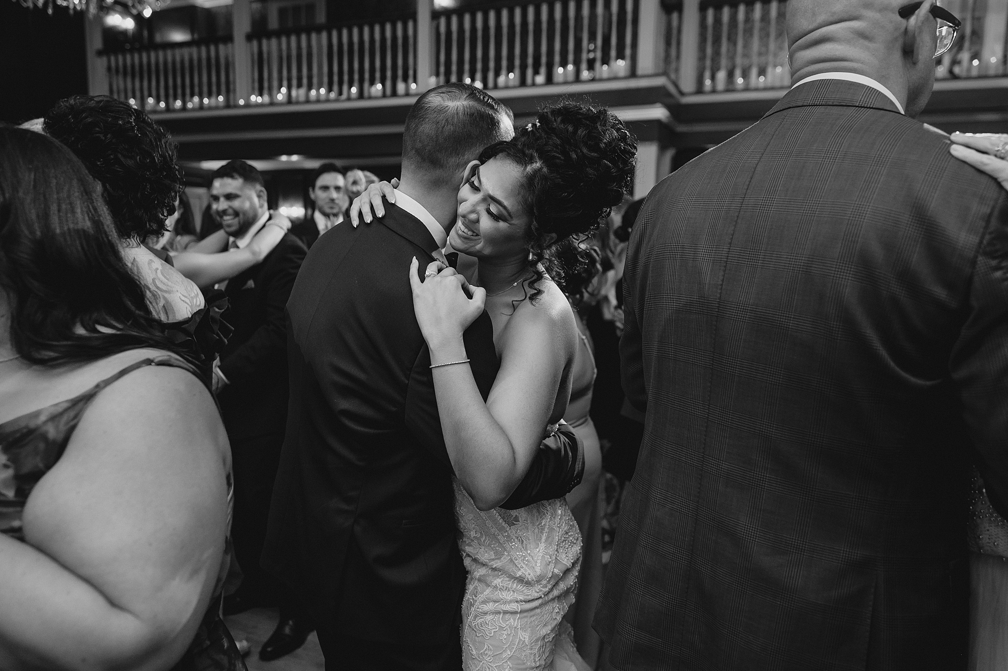 bride and groom hug close surrounded by guests during wedding reception dance in Hackettstown NJ