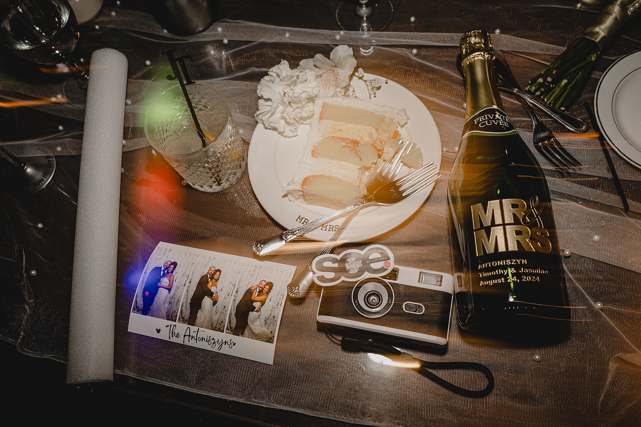 slice of wedding cake with vintage camera, custom champagne bottle and printed Photo Booth photos 