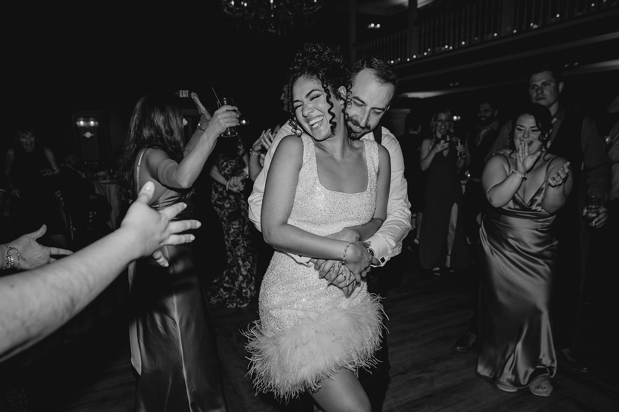 groom hugs bride in short cocktail dress with fringe on the bottom
