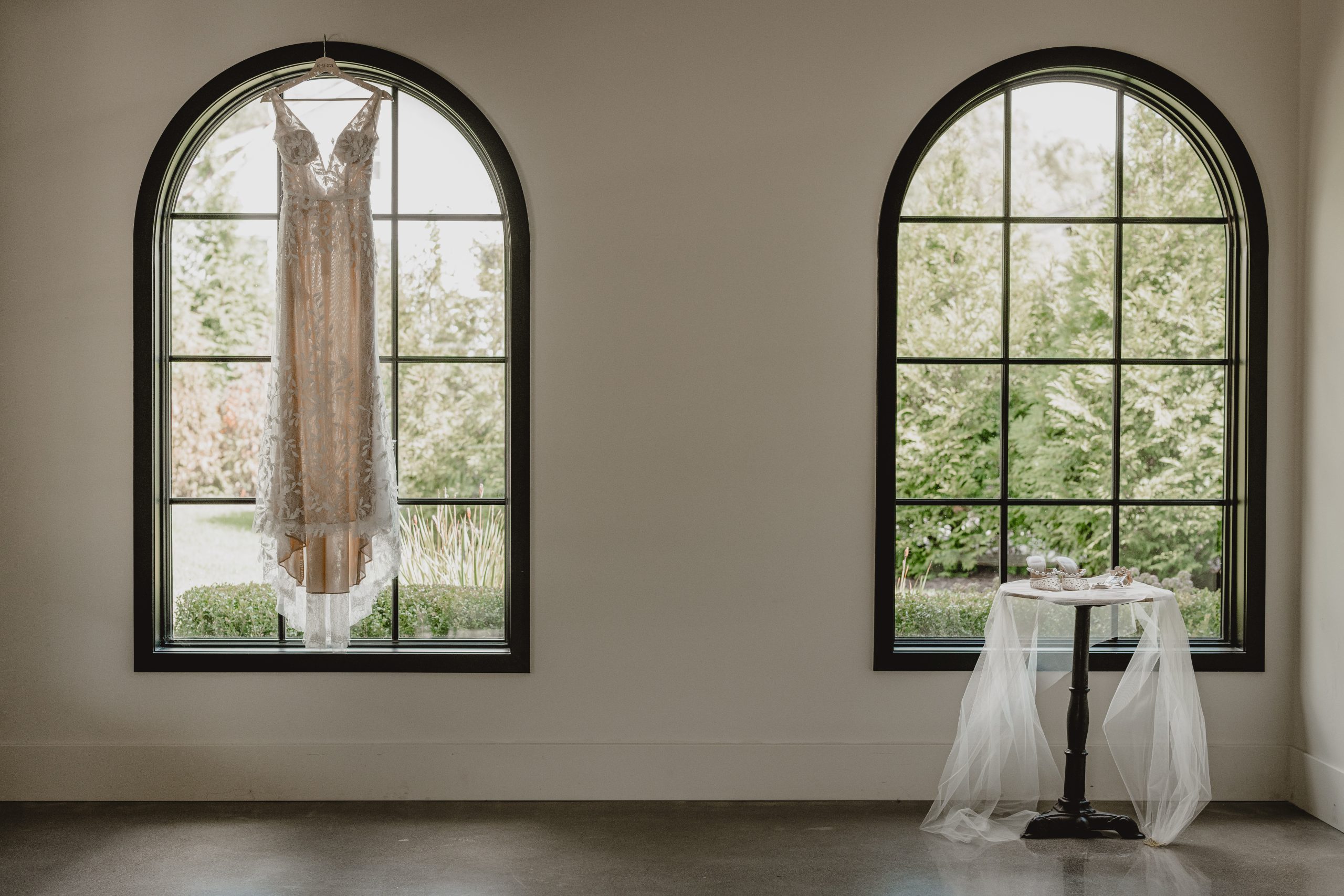 wedding dress hangs in window of the Perona Farms Refinery