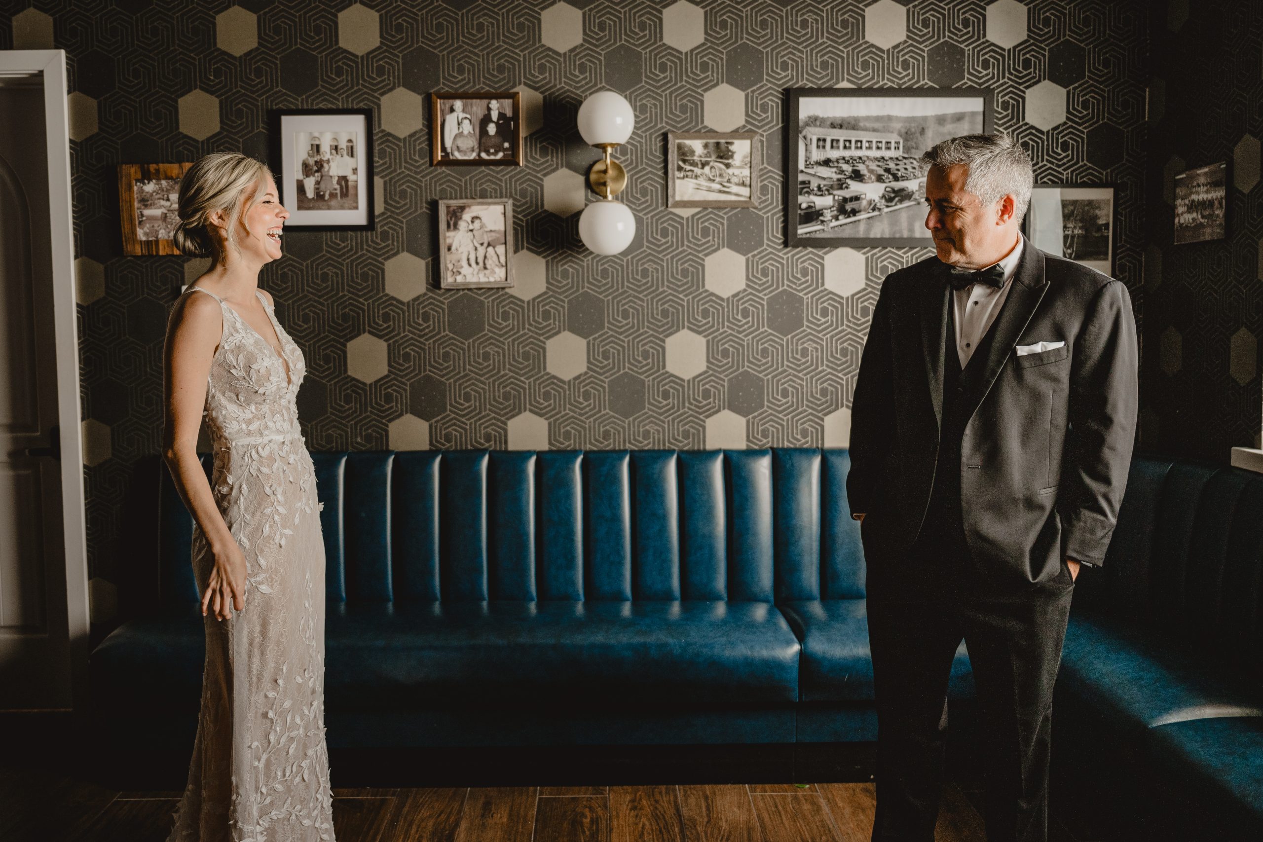 bride laughs during first look with dad in groom's suite at the Perona Farms Refinery