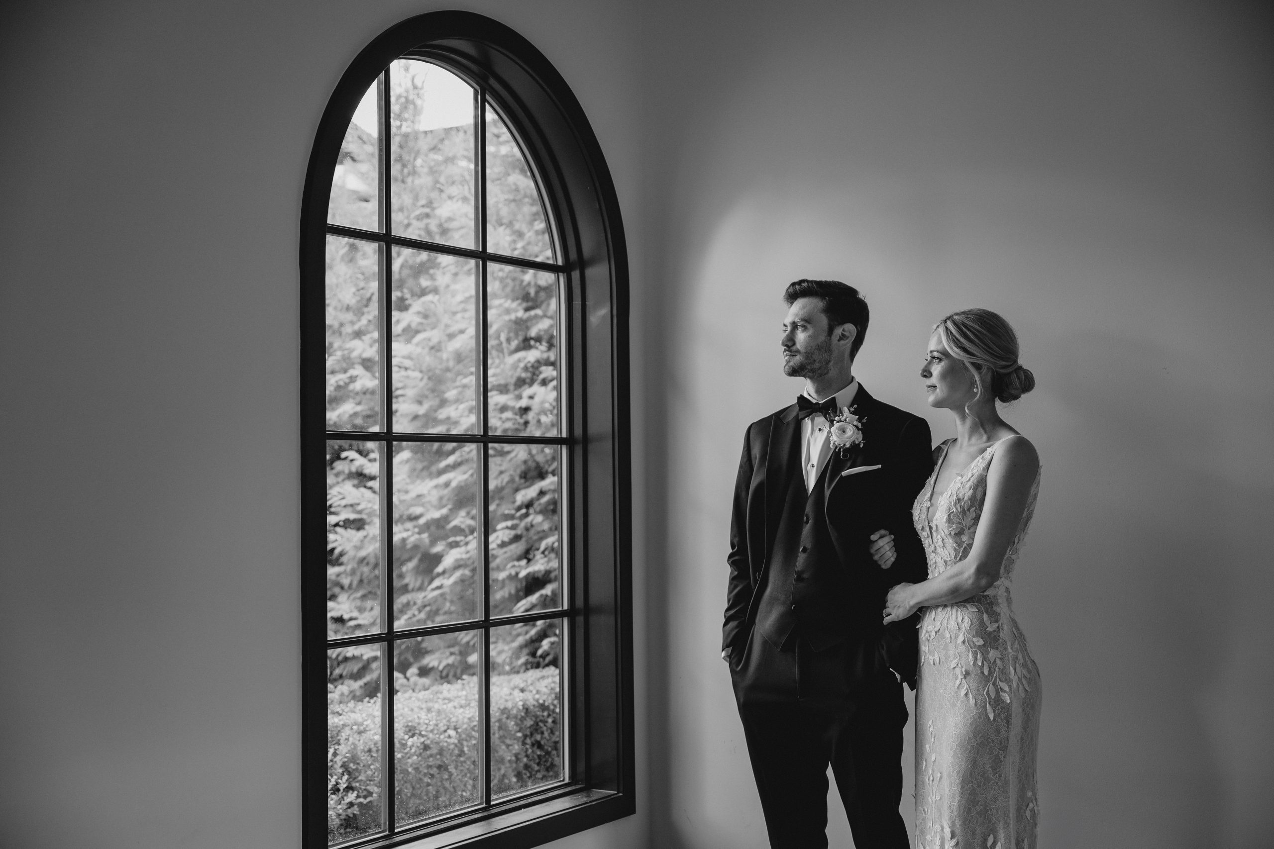 black and white photo of bride and groom looking out window at the Perona Farms Refinery