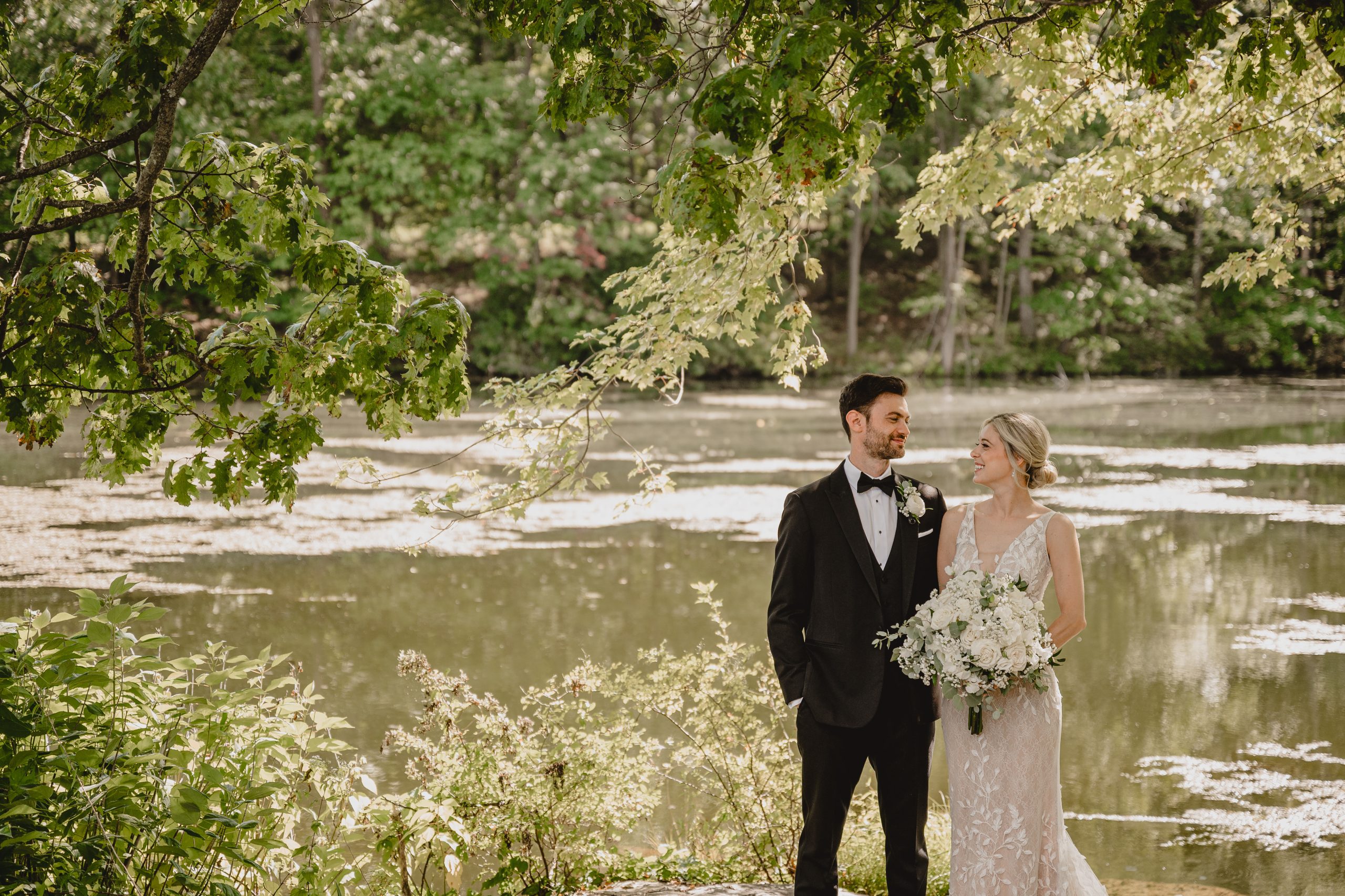 newlyweds hug near pond in Andover NJ during wedding photos