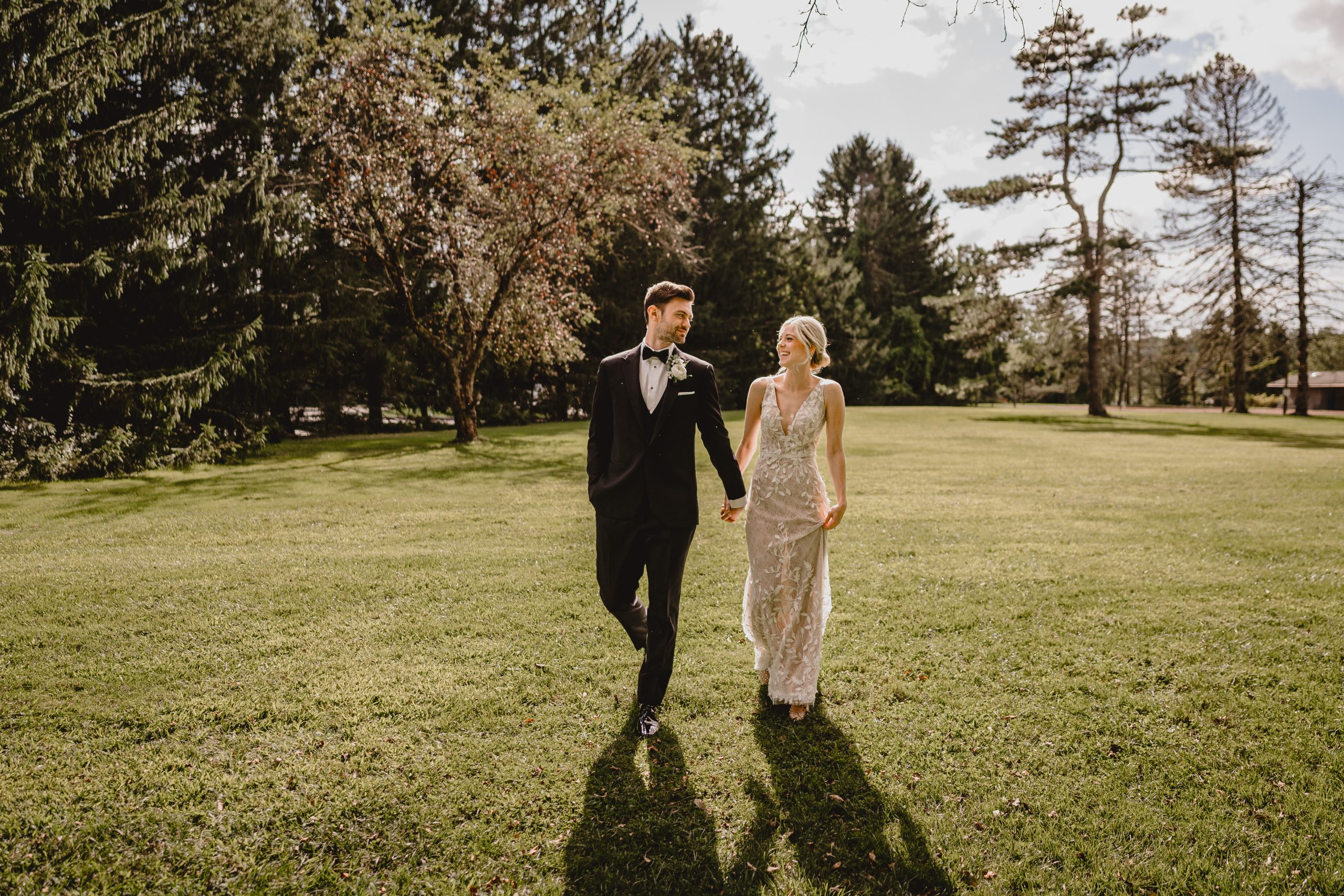 bride and from hold hands walking across lawn in Andover New Jersey