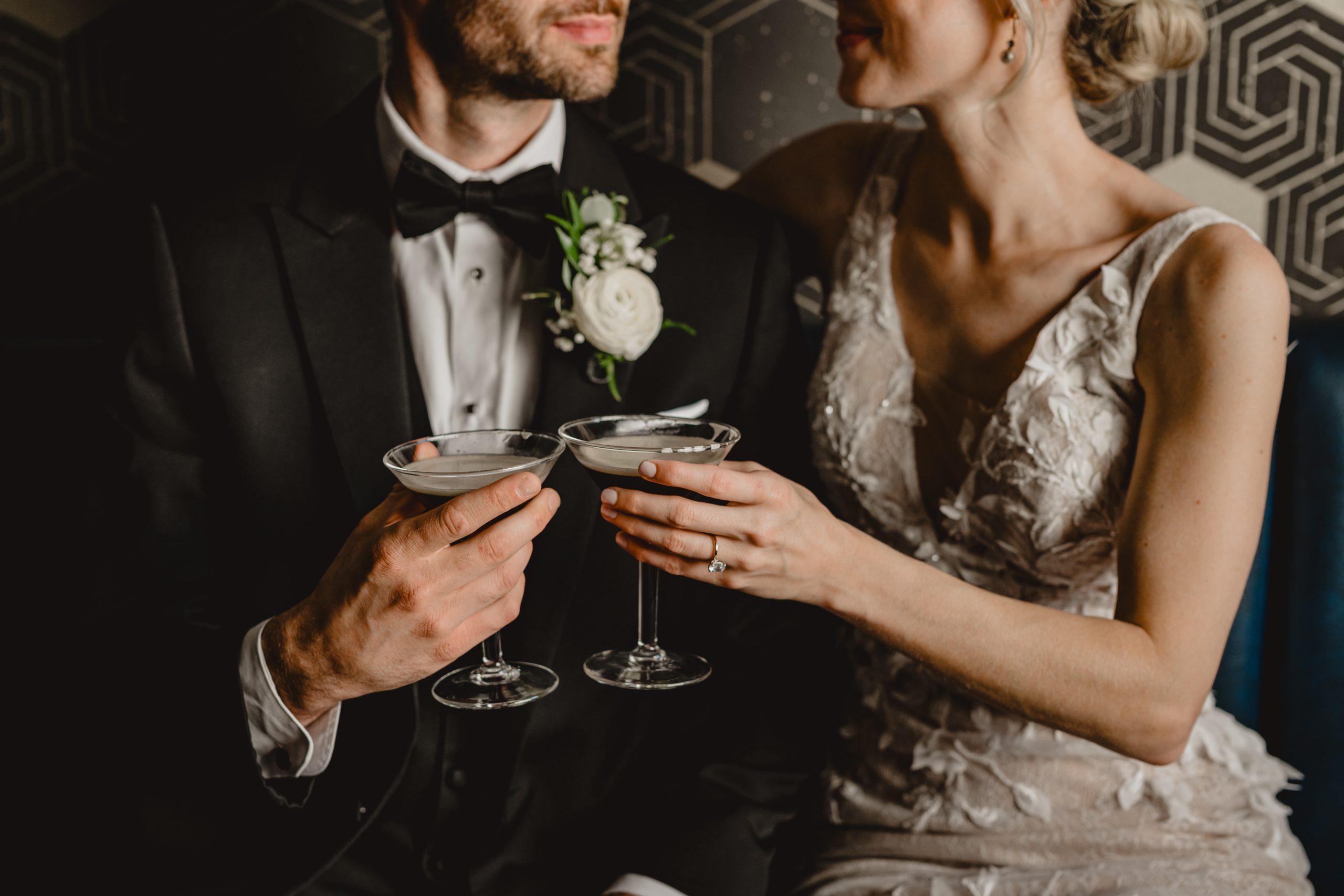 newlyweds toast espresso martinis during wedding photos on couch 
