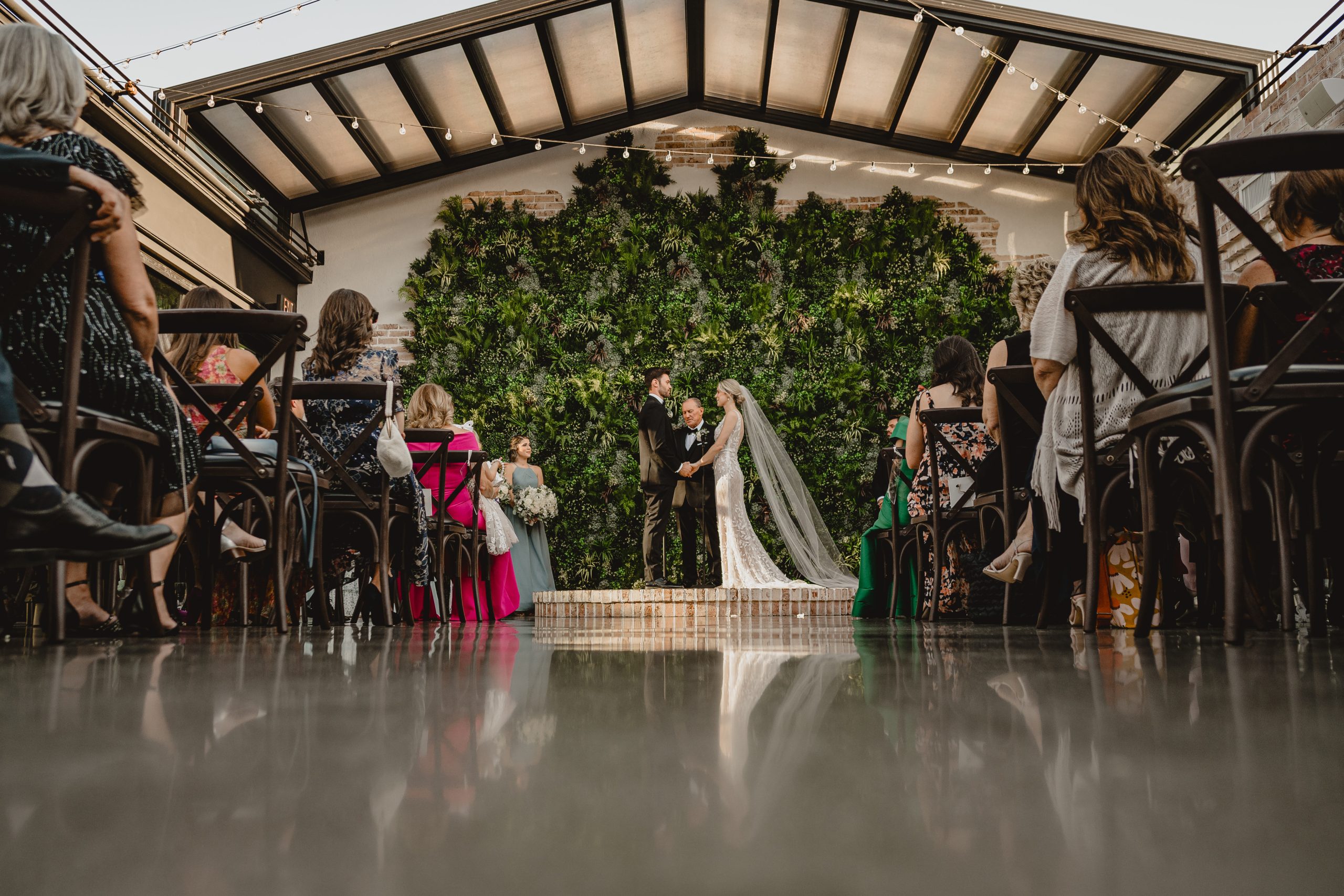 photo of bride and groom holding hands on brick dais from the ground up