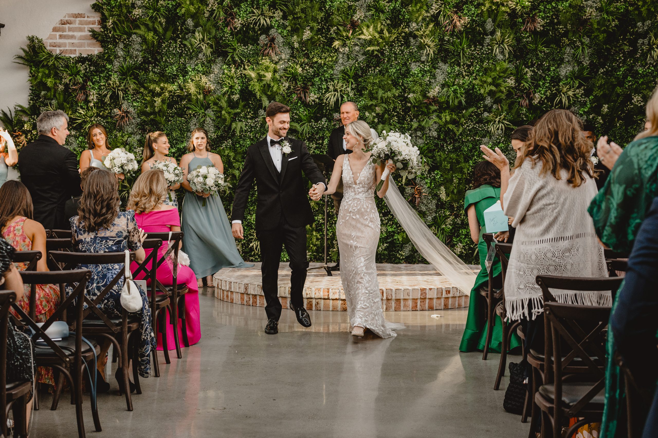newlyweds hold hands walking away from brick dais after wedding ceremony in Andover NJ