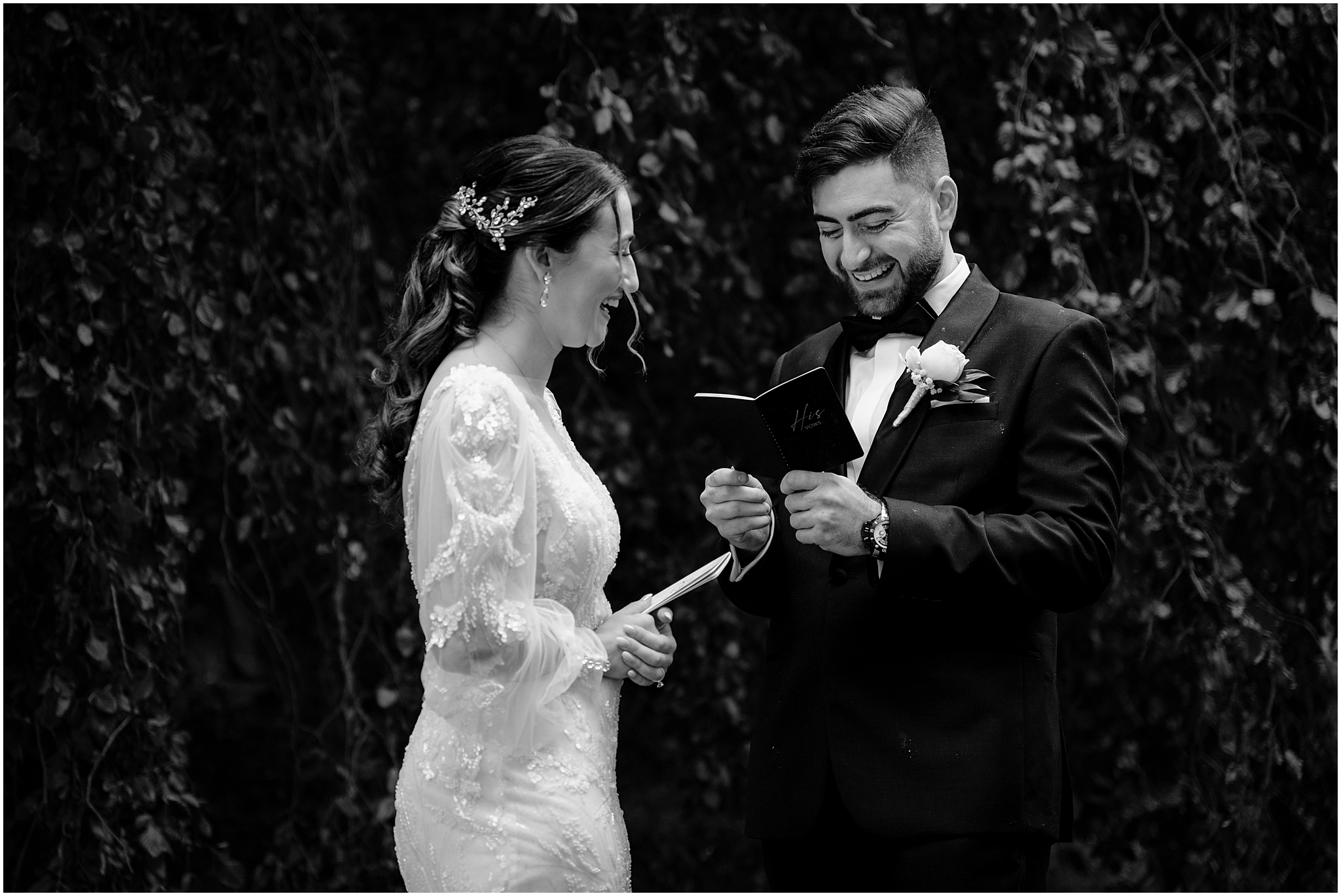 groom grins reading vows from booklet to bride during first look
