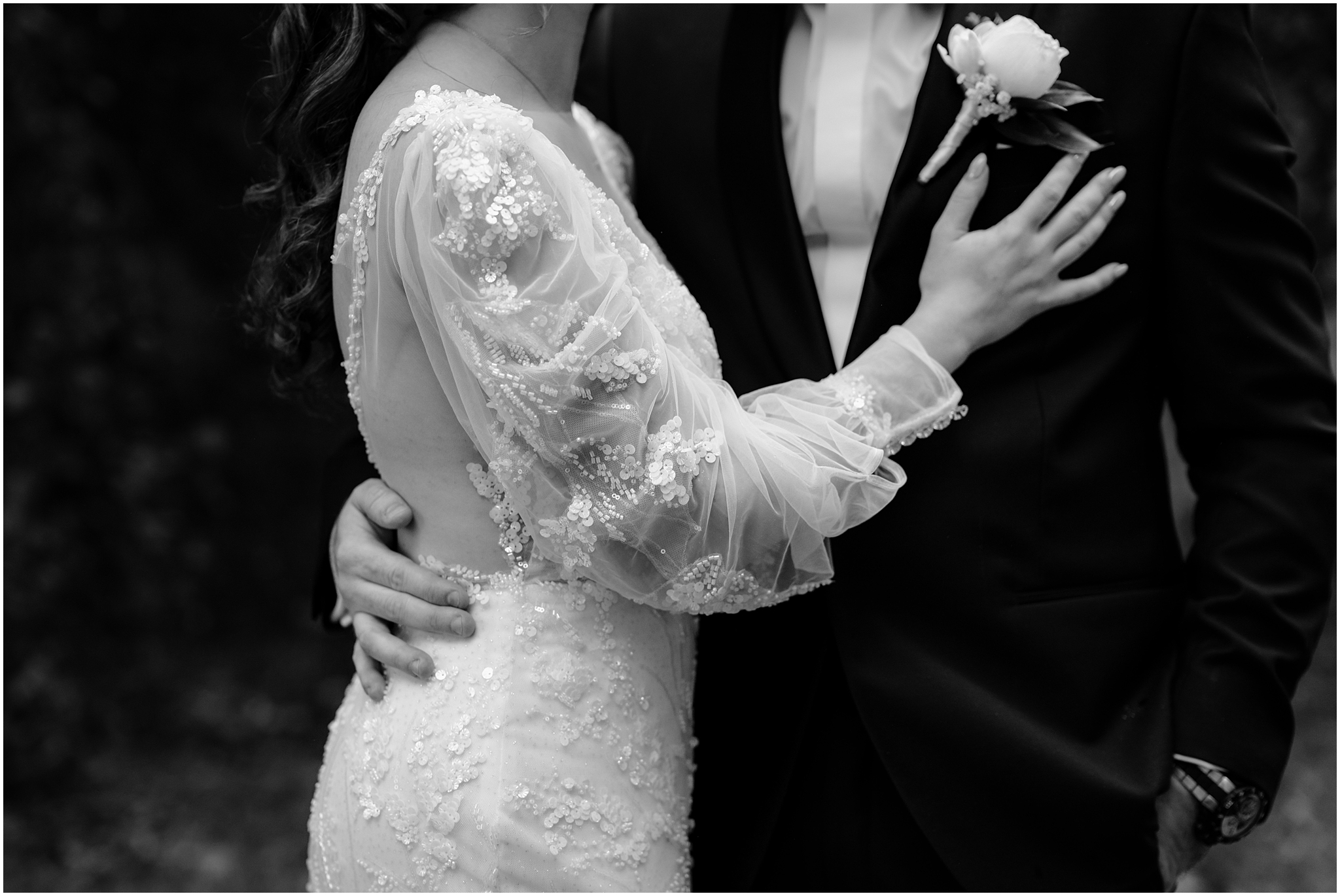 black and white photo of sequin detailing on bride's sleeve and gown