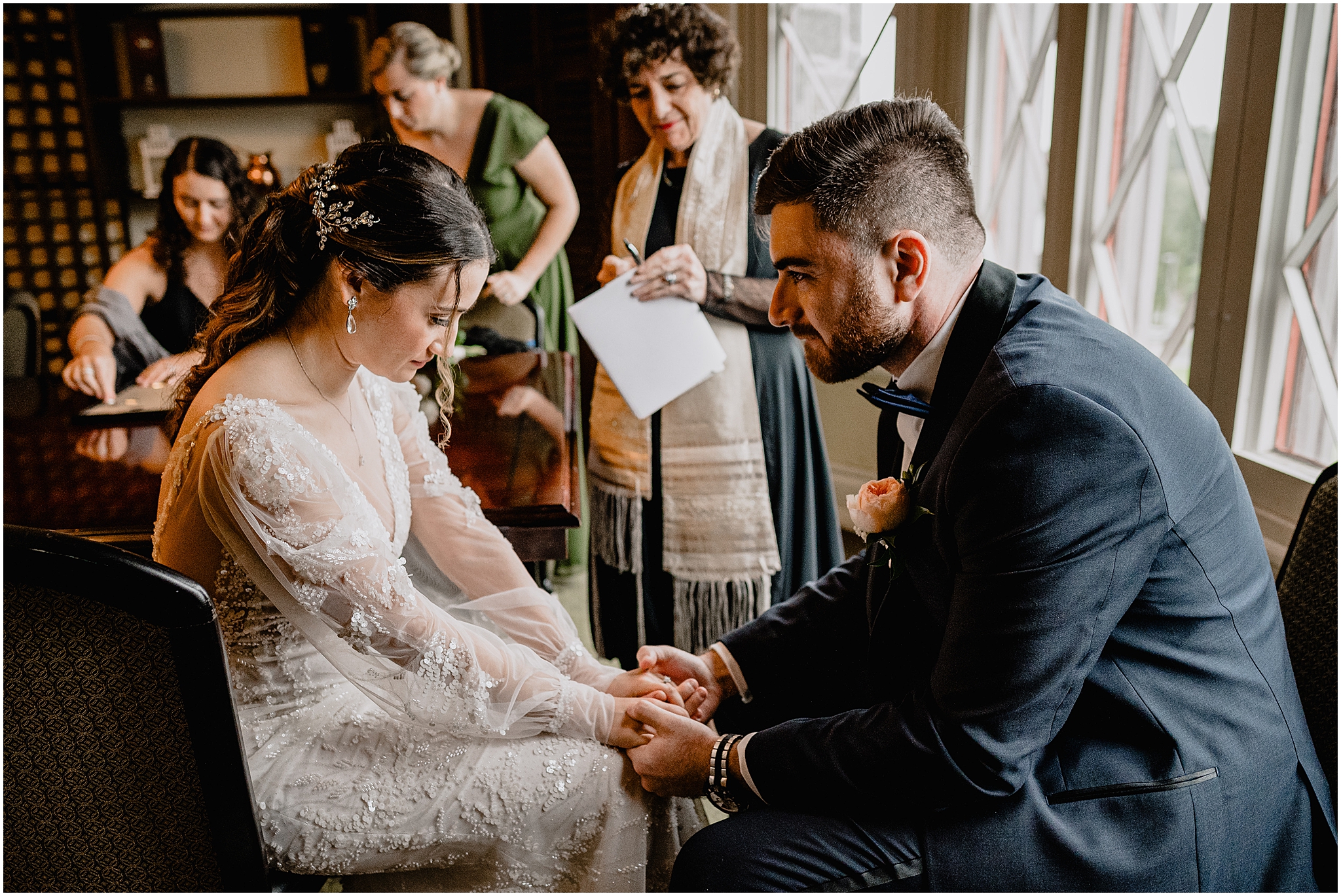 bride and groom hold hands during ketubah signing