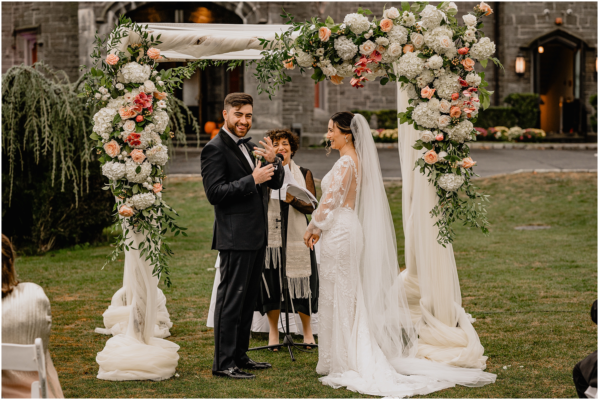 groom shows off ring during Jewish wedding ceremony on the lawn at Whitby Castle