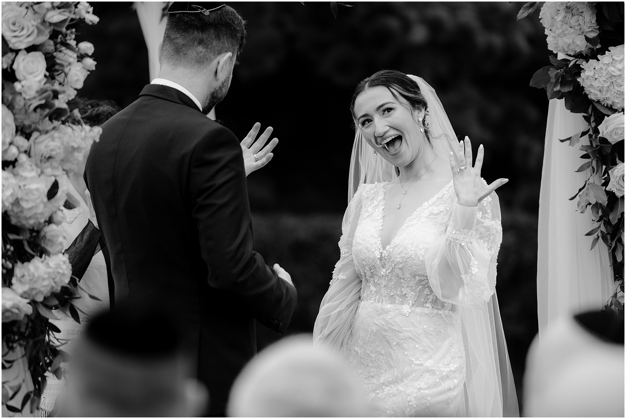 bride grins showing off wedding bands during ceremony at Whitby Castle