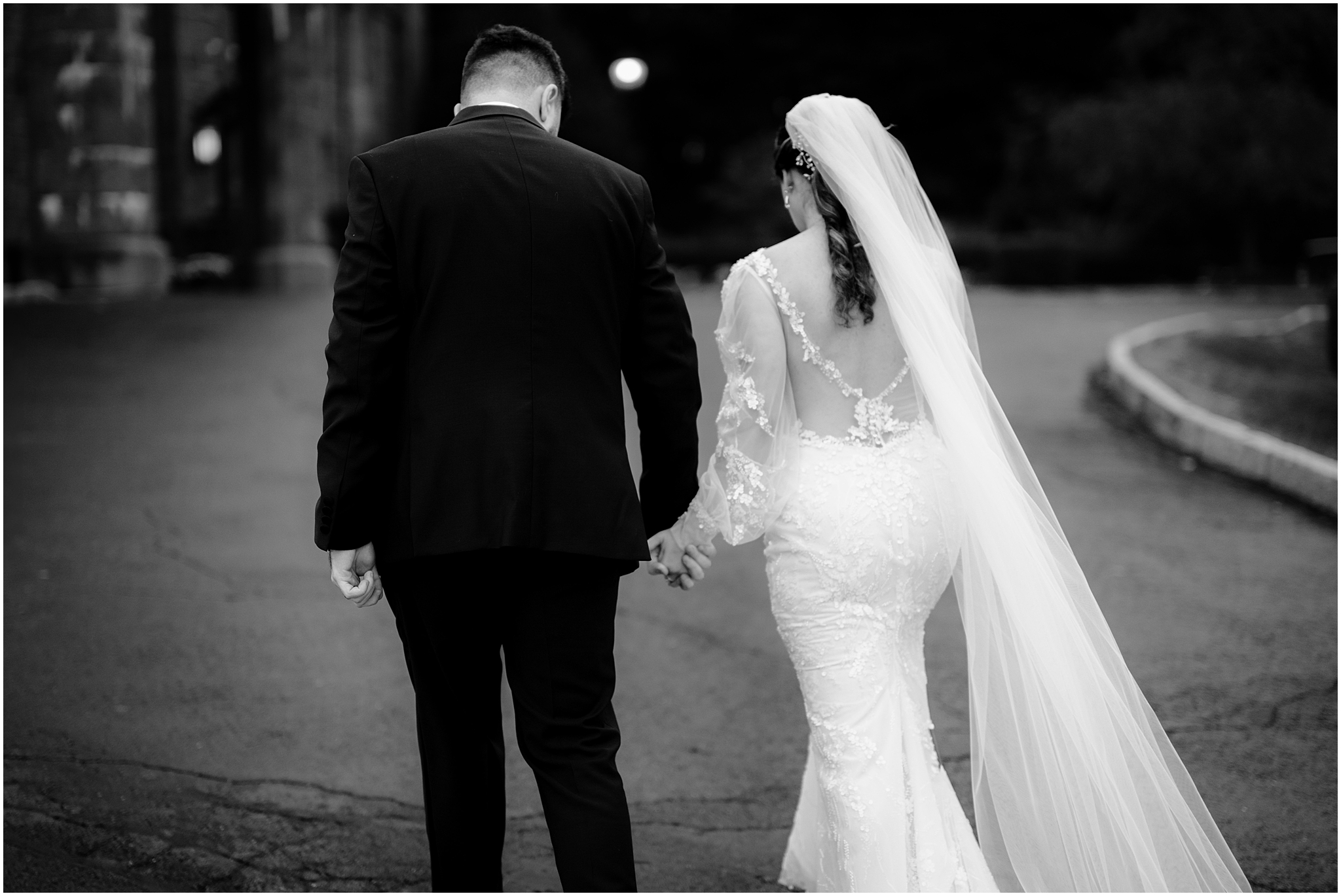 bride and groom hold hands walking outside Whitby Castle
