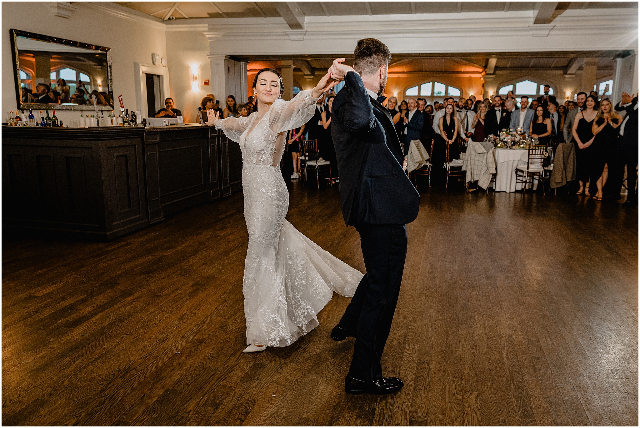 groom twirls bride behind him during first dance inside Whitby Castle