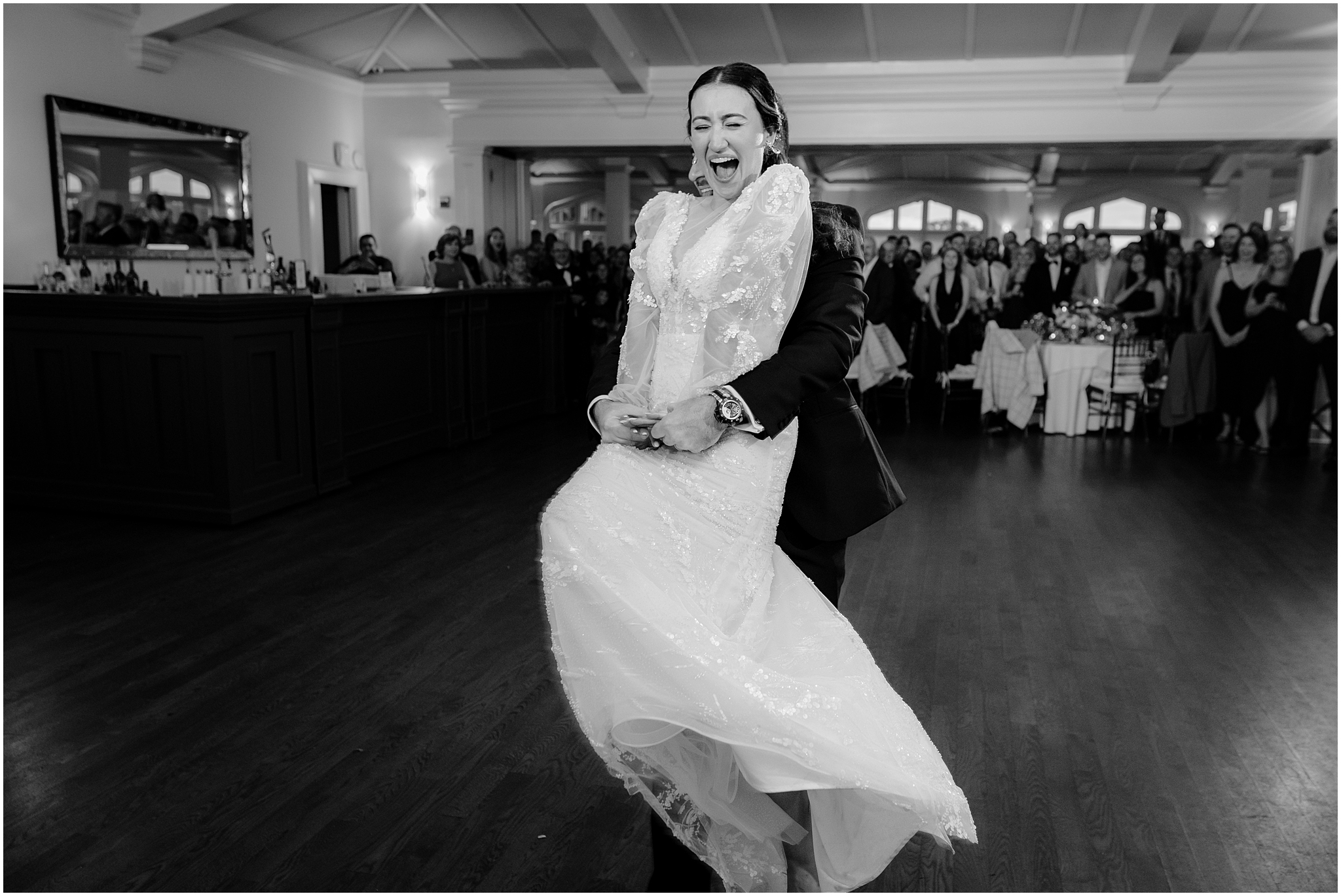 bride laughs while groom twirls her around on dance floor at Whitby Castle