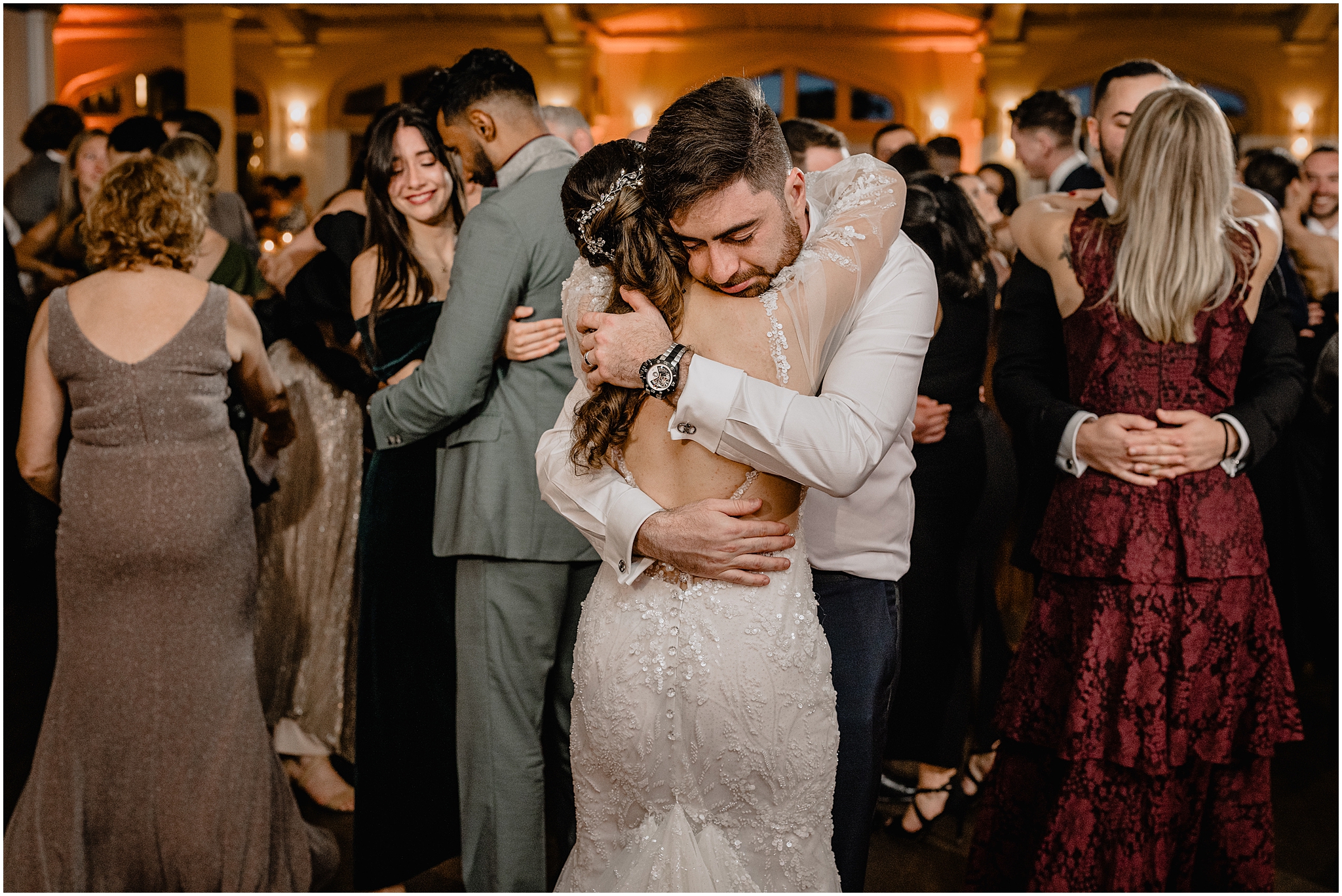 bride and groom hug on dance floor during reception at Whitby Castle