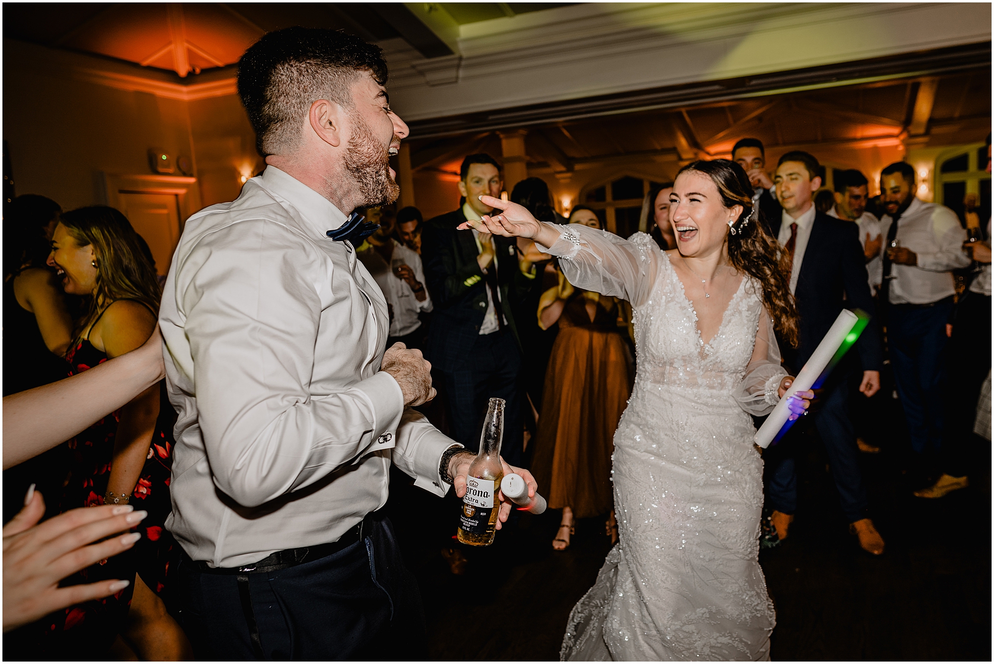 bride and groom dance together with glow sticks during reception at Whitby Castle