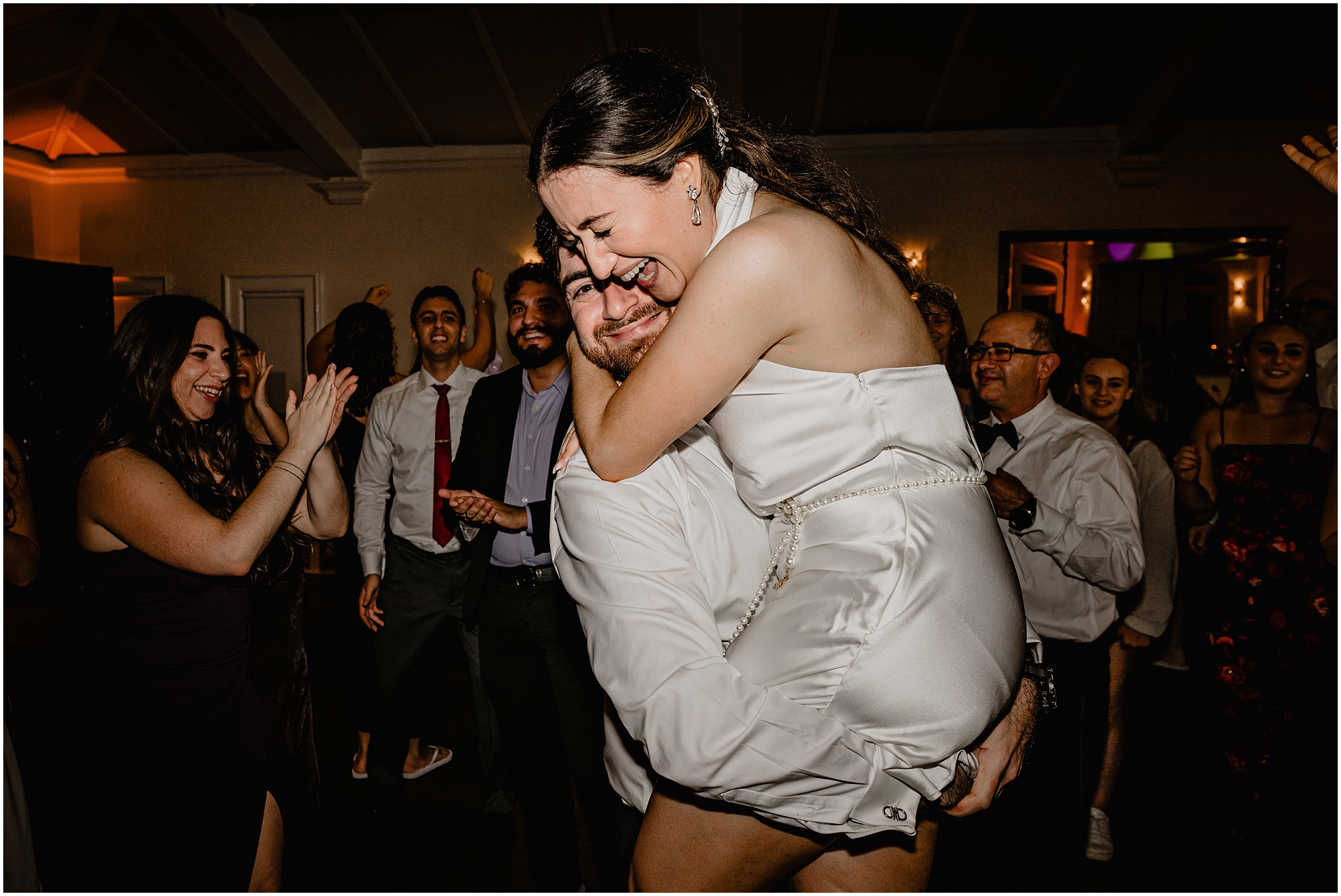 groom lifts up bride in second reception party dress