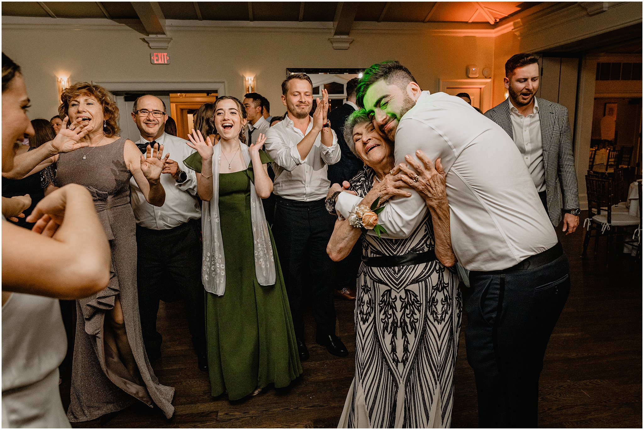 groom hugs grandmother on dance floor during wedding reception 