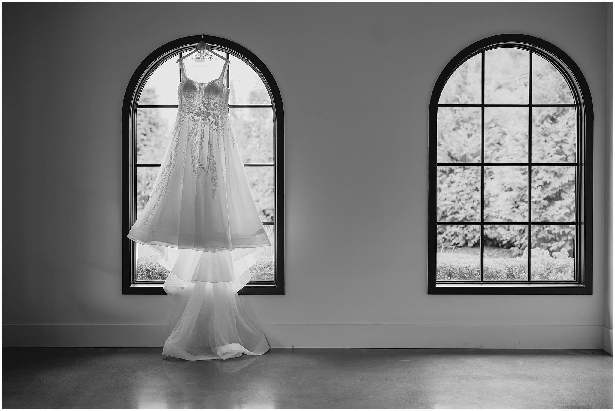 wedding dress hangs in the window at the Refinery at Perona Farms