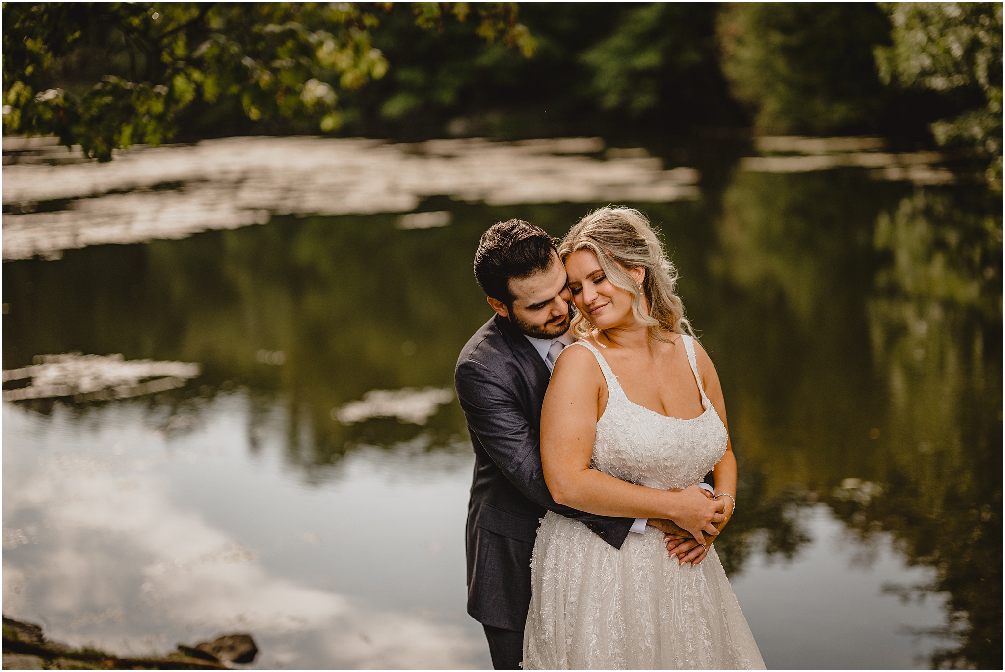 groom stands behind bride hugging her and leaning their heads together in Andover NJ