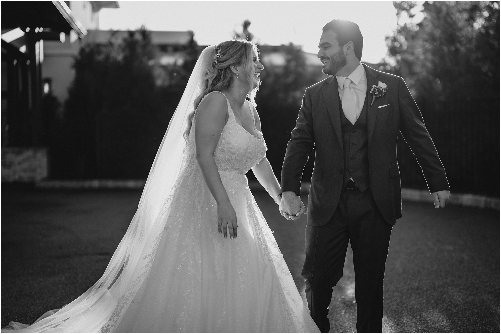 newlyweds hold hands laughing during the Refinery at Perona Farms wedding photos