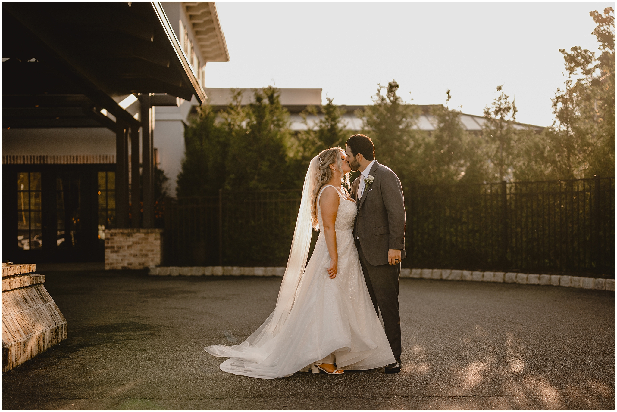 bride and groom kiss by front door of the Refinery at Perona Farms