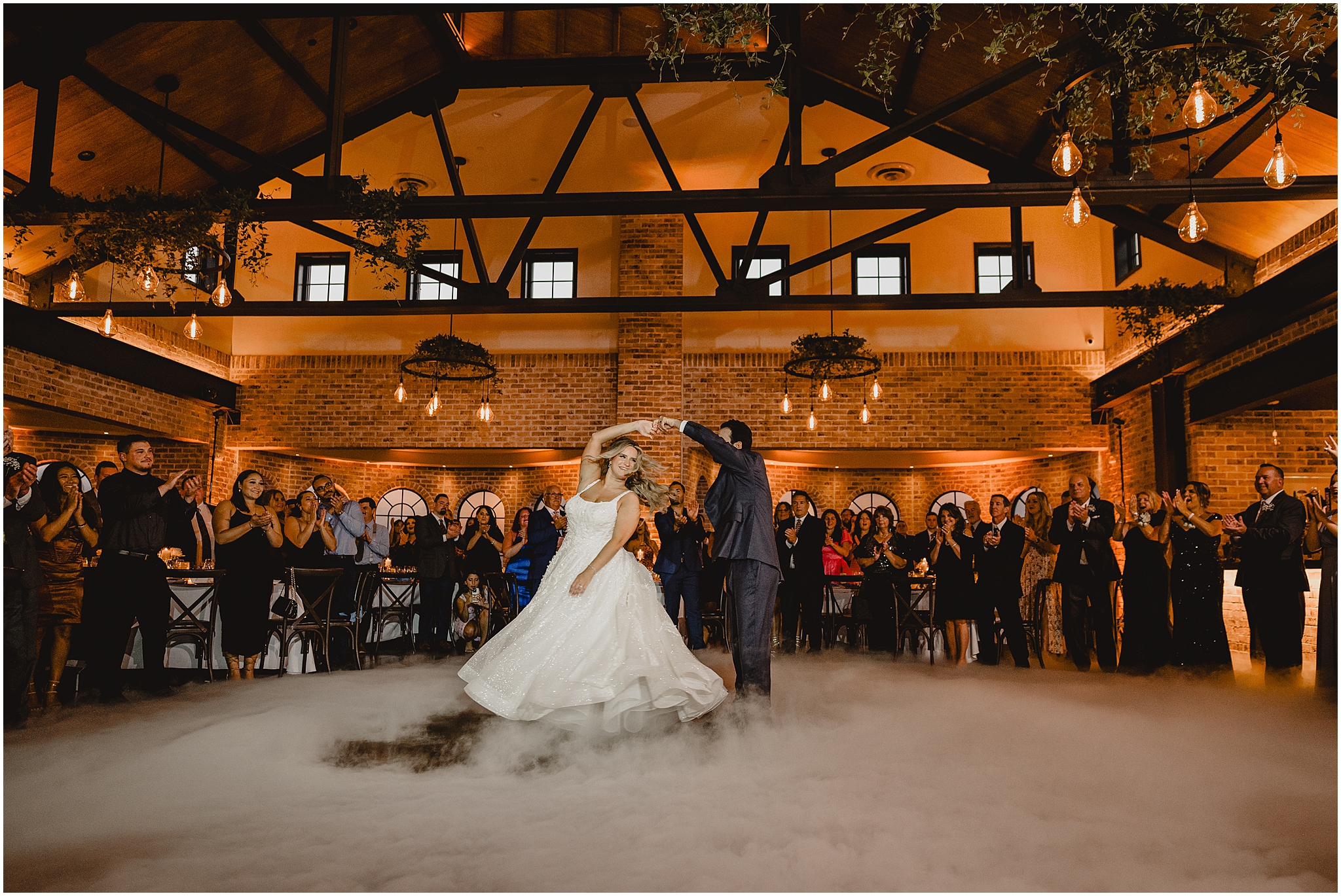groom twirls bride during first dance at the Refinery at Perona Farms with fog around them