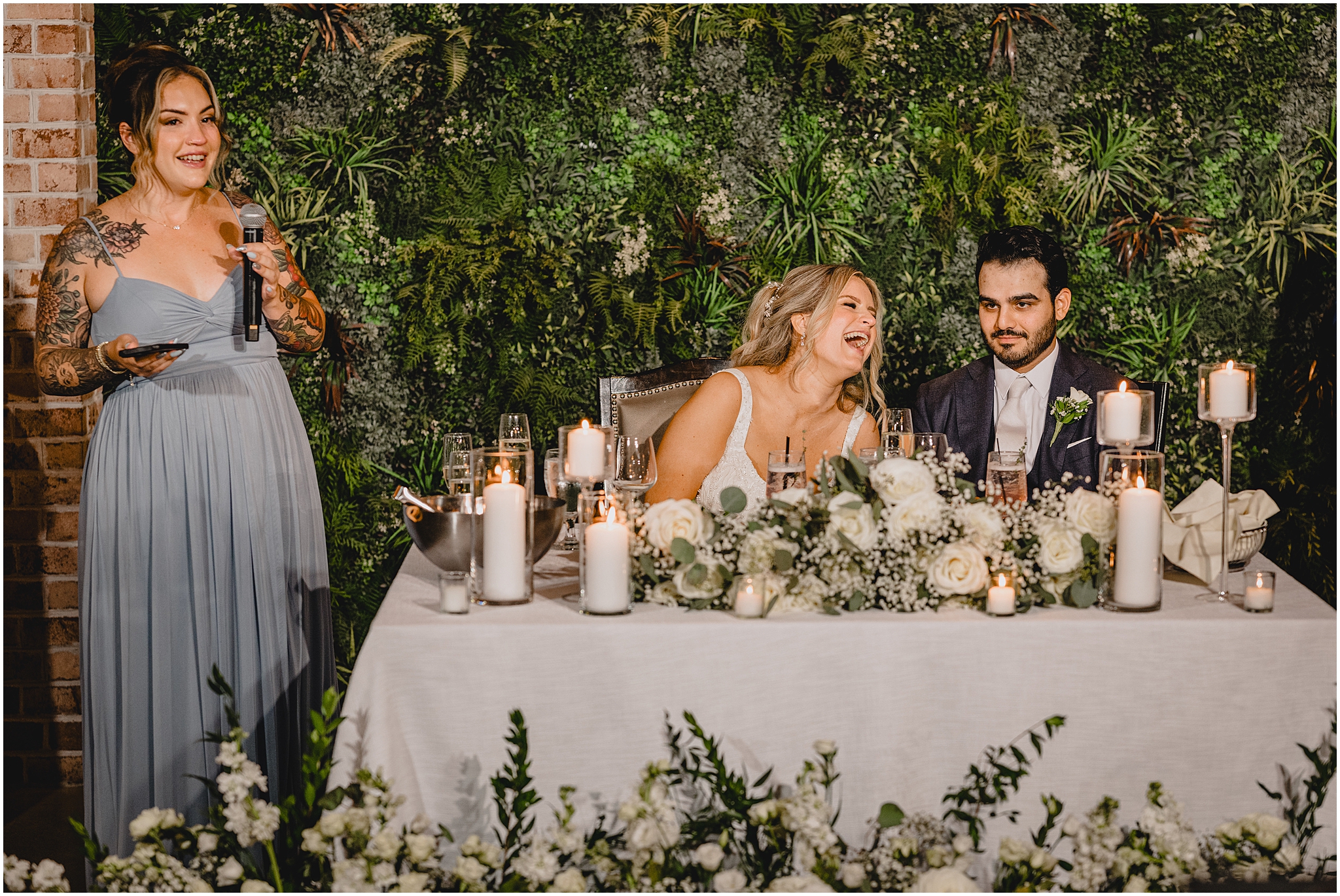 newlyweds laugh during bridesmaids' speech during reception 