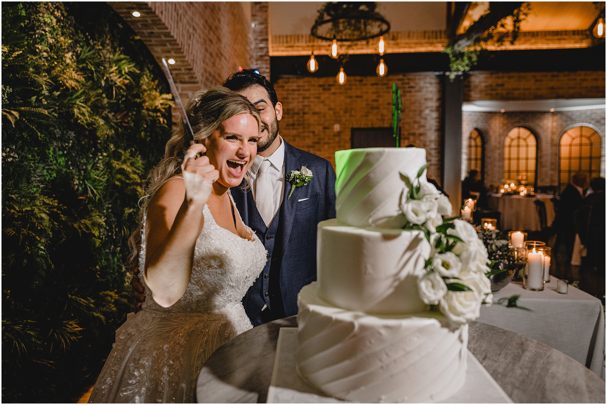 bride laughs holding up knife to cut wedding cake during Andover NJ wedding reception 