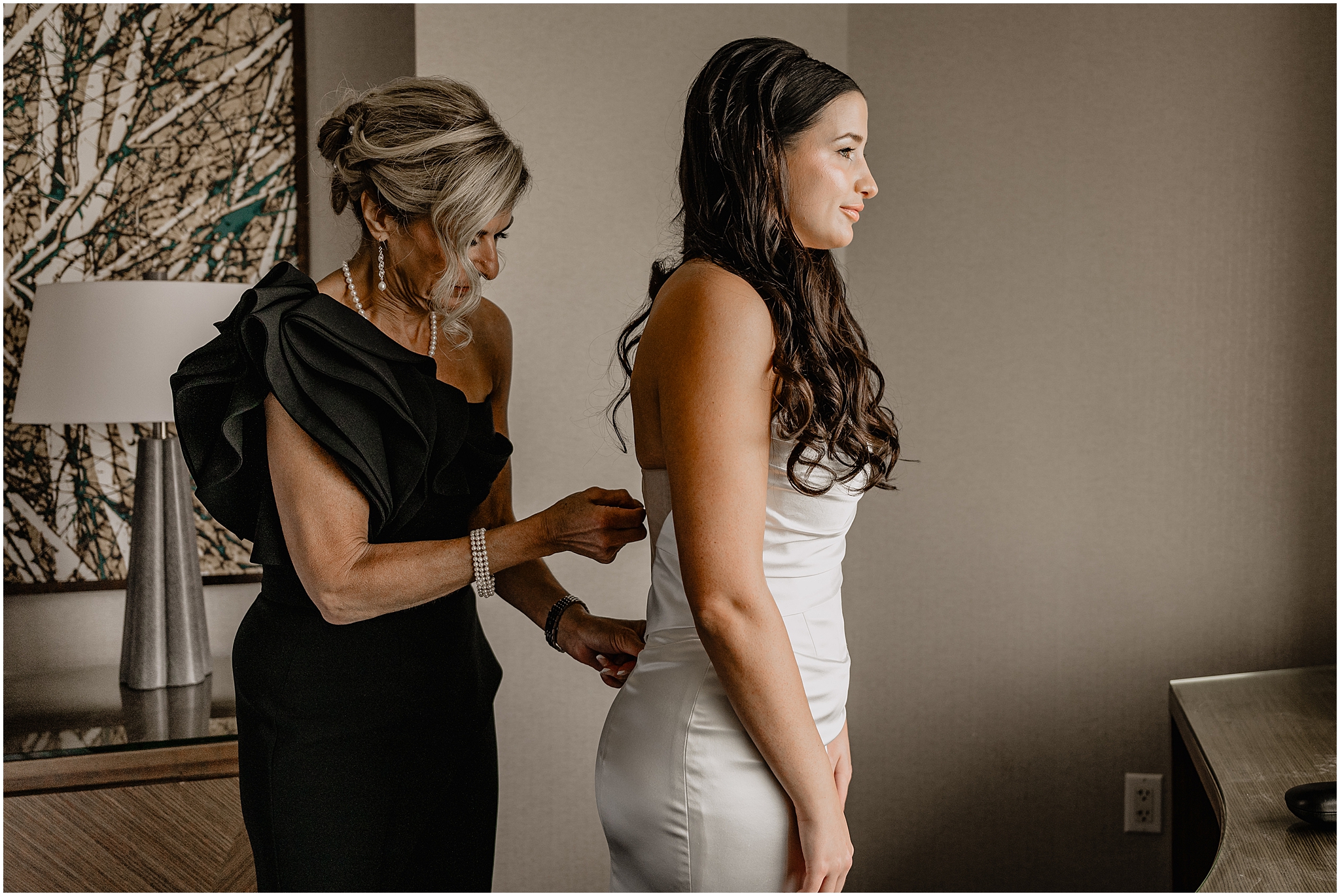 mother zips up bride's wedding gown during prep for wedding in NJ hotel room