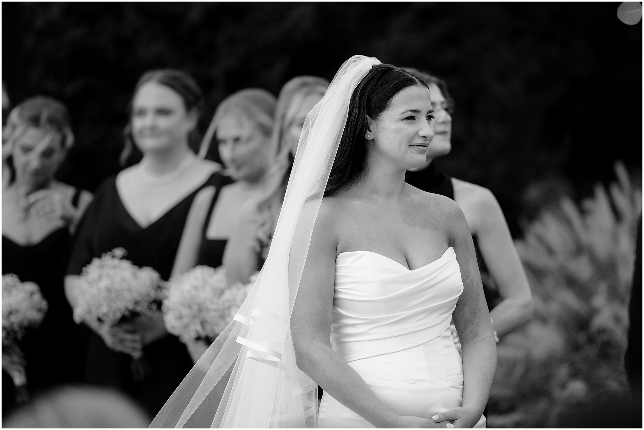 bride listens during wedding ceremony on lawn at the Liberty House