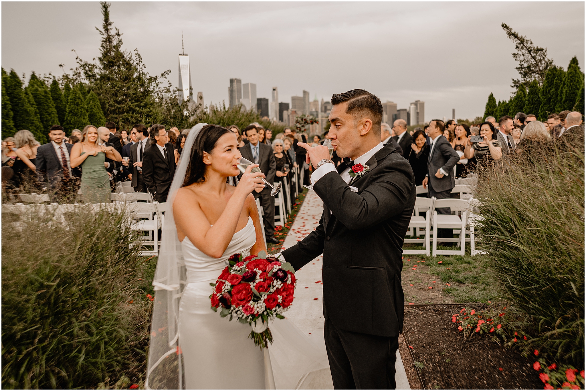 newlyweds pause at the end of the aisle to drink champagne after wedding ceremony at the Liberty House