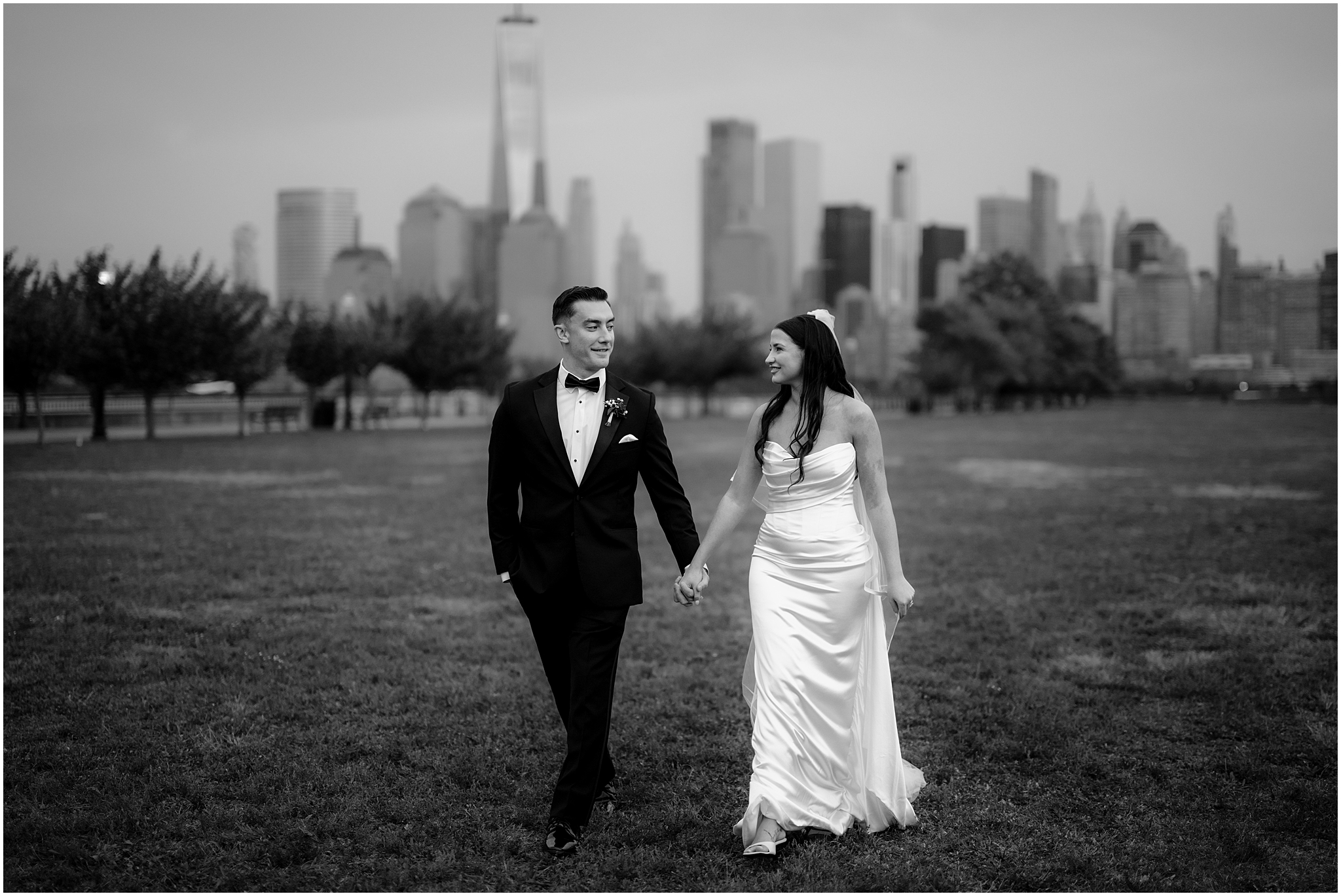 bride and groom hold hands walking on lawn outside the Liberty House