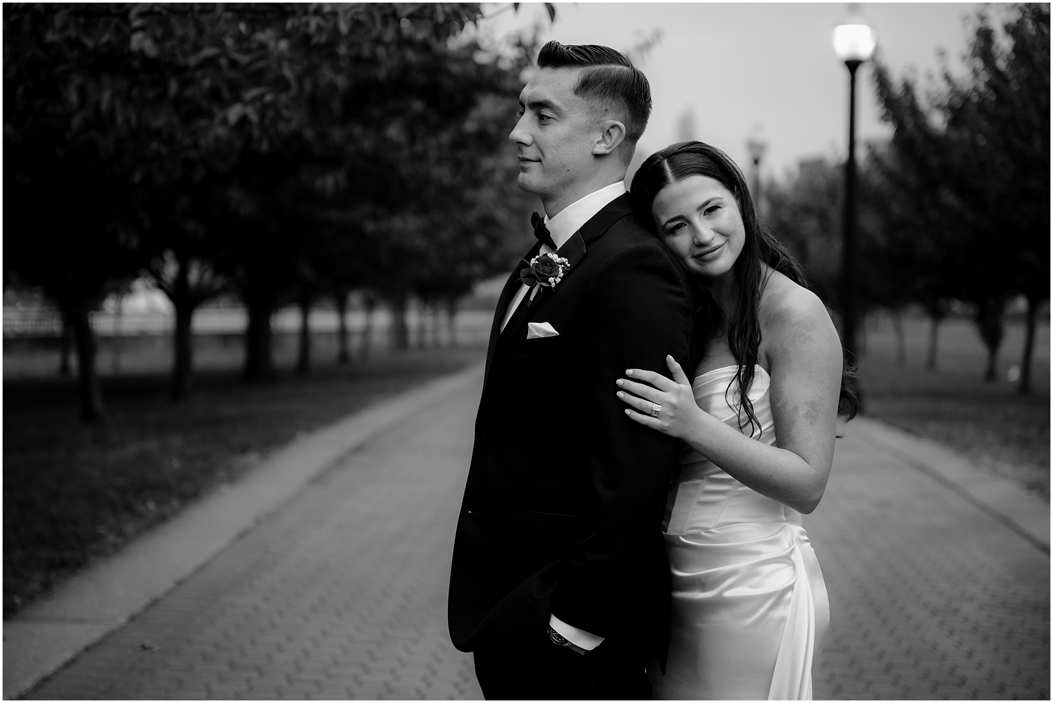 bride leans her head on groom's back during wedding portraits in New Jersey 