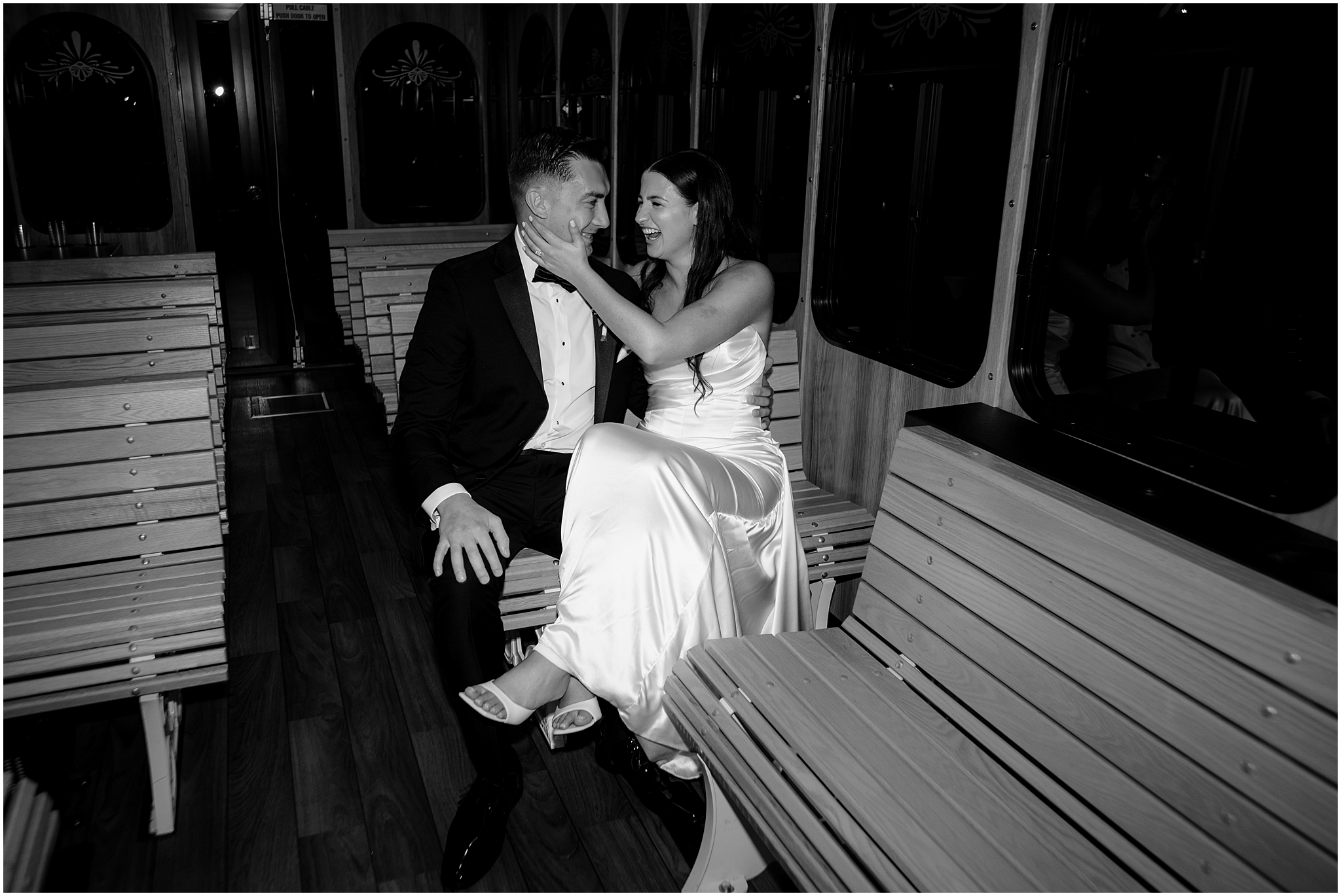 newlyweds sit together on wooden bench on trolley 